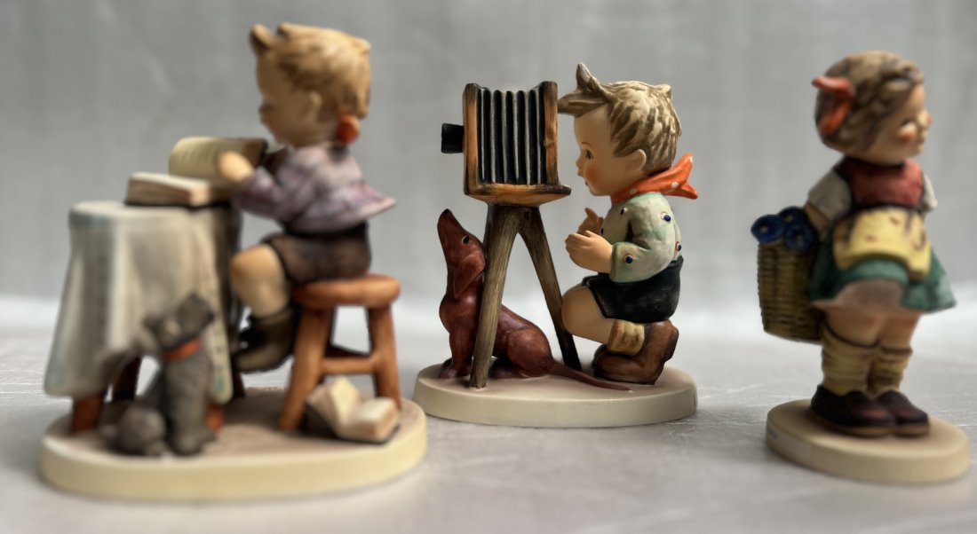 LOT OF THREE GOEBEL FIGURINE, "THE PHOTOOGRAPHER""BASHFUL" & "LITTLE BOOKKEEPER": LOT OF THREE GOEBEL FIGURINE, "THE PHOTOOGRAPHER""BASHFUL" & "LITTLE BOOKKEEPER" This lot of three Goebel figurines includes "Birthday Candle," "Hello I'm Here," and "Girl With a Doll." Each figurine