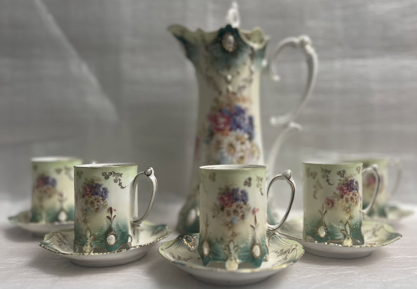Vintage Prussia Chocolate Pot with 5 cups w Saucers Circa 1900s: This vintage chocolate pot from Prussia is a stunning piece of art pottery that will add a touch of elegance to any collection. With a beautiful floral pattern in multicolor and a glossy finish, this 