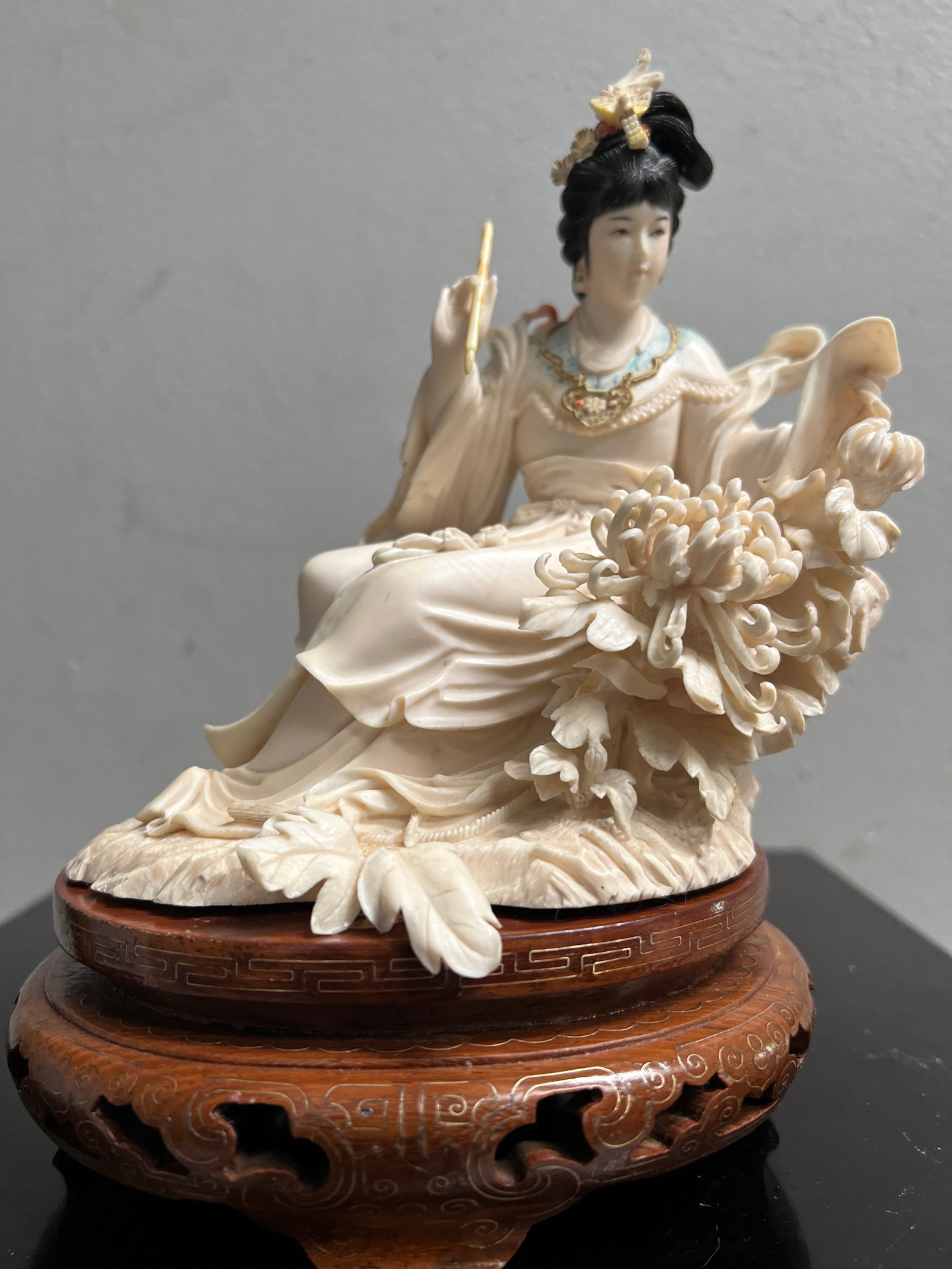 Stunning Early 20C Chinese Hand Carved Empress on a Wood Base: This exquisite piece is a stunning example of Chinese artistry from the early 20th century. The hand-carved figurine features a beautiful ivory color and depicts an Empress sitting on a wooden base. T