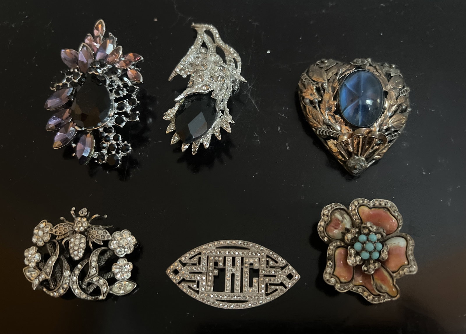 A Collection of 6 Stunning Boockes: Adorn your ensemble with a touch of elegance with this collection of 6 Boockes brooches. Each piece showcases a unique design, bursting with vibrant multicolor stones that promise to add a sparkle to 