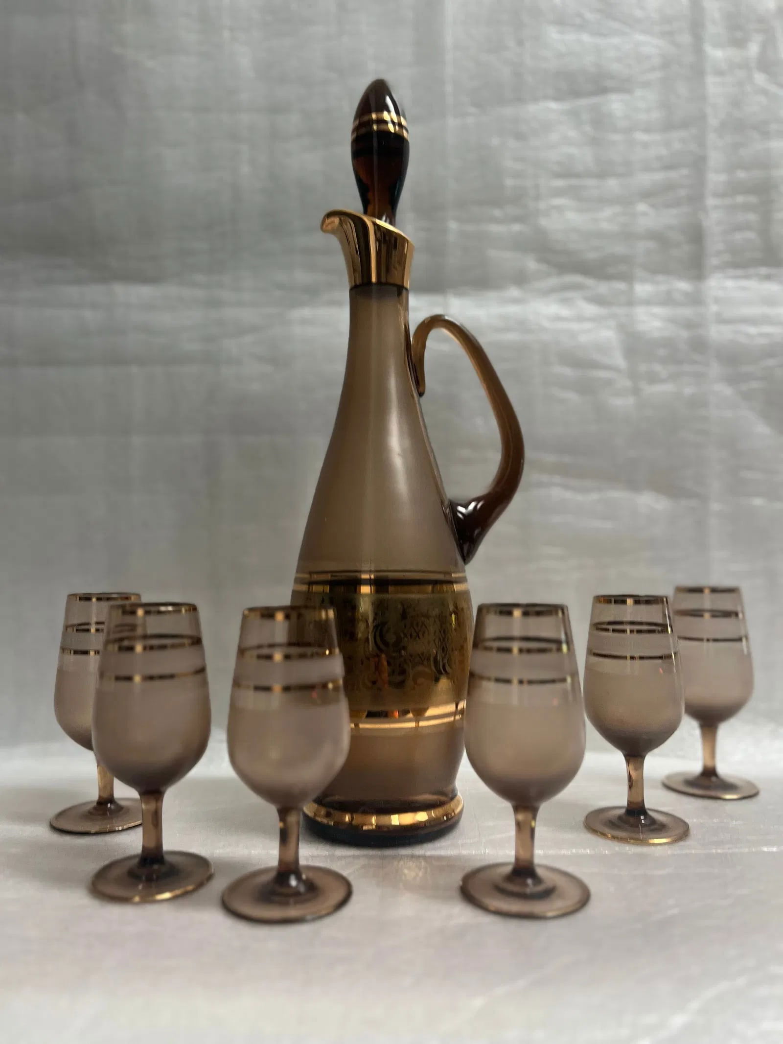 Vintage Bohemia Amber Decanter and Set of 6 Glasses, Glod and Amber: This vintage decanter set, made in Bohemia, features a beautiful amber color and includes six matching glasses. The decanter and glasses are made of high-quality glass, adding a touch of elegance to a