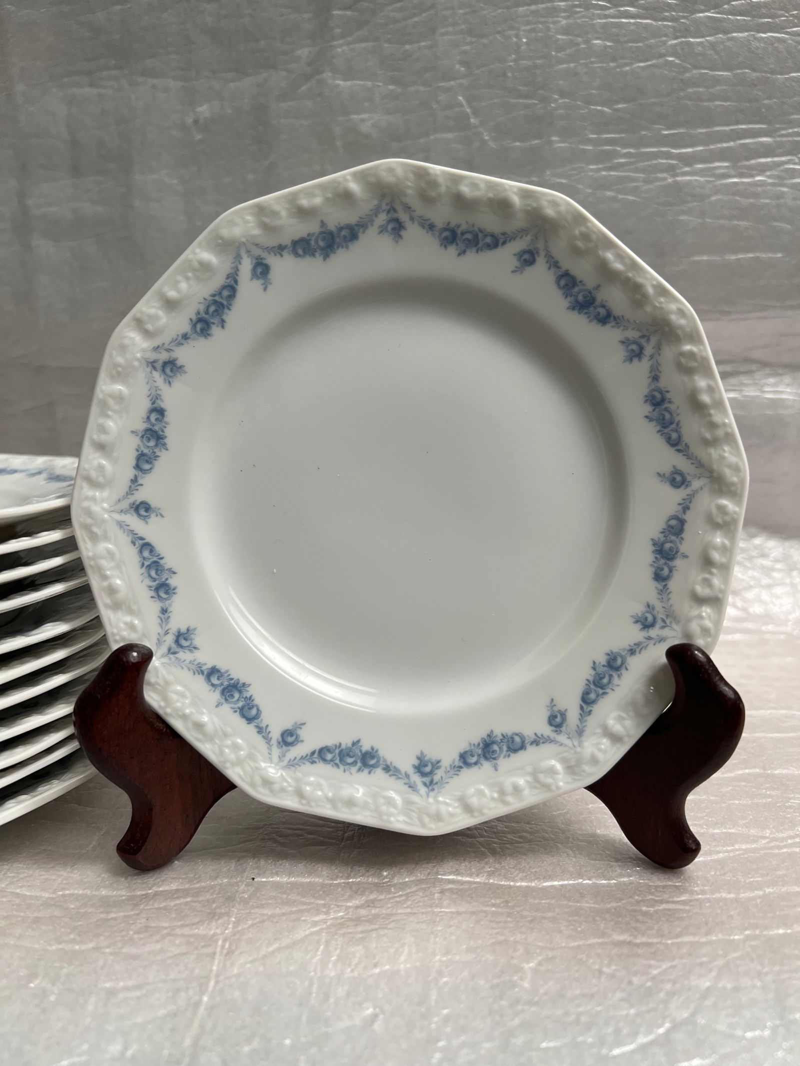 Set of 11 Vintage in New Condition Rosenthal Maria 11" Porcelain Dinnerware Plates Circa 1960s: Product: Rosenthal Maria porcelain dinnerware, specifically the "Maria Rosenkante Blau" or "Dream Blue" pattern. Design: Features a polygonal shape with a characteristic embossed fruit wreath rim and