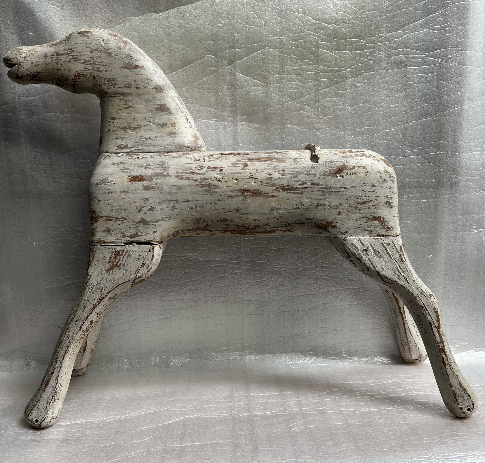 Vintage Hand-Carved Wooden Riding Horse: This is a charming piece of vintage folk art, likely a primitive-style wooden riding toy or decorative horse.Here is a detailed description of the item based on the image:Primitive Wooden Folk Art Hor