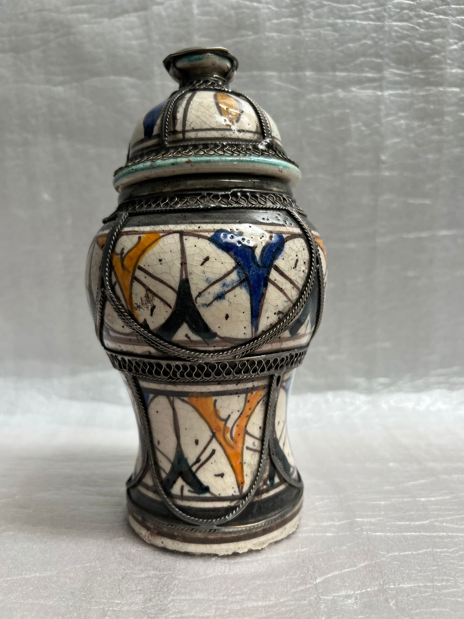 Moroccan Ceramic Lidded Jar: This is a beautiful piece! This lidded jar is a fine example of Moroccan ceramic artistry with intricate metalwork.Detailed Description of the Lidded Jar• Origin and Style: This jar is characteri