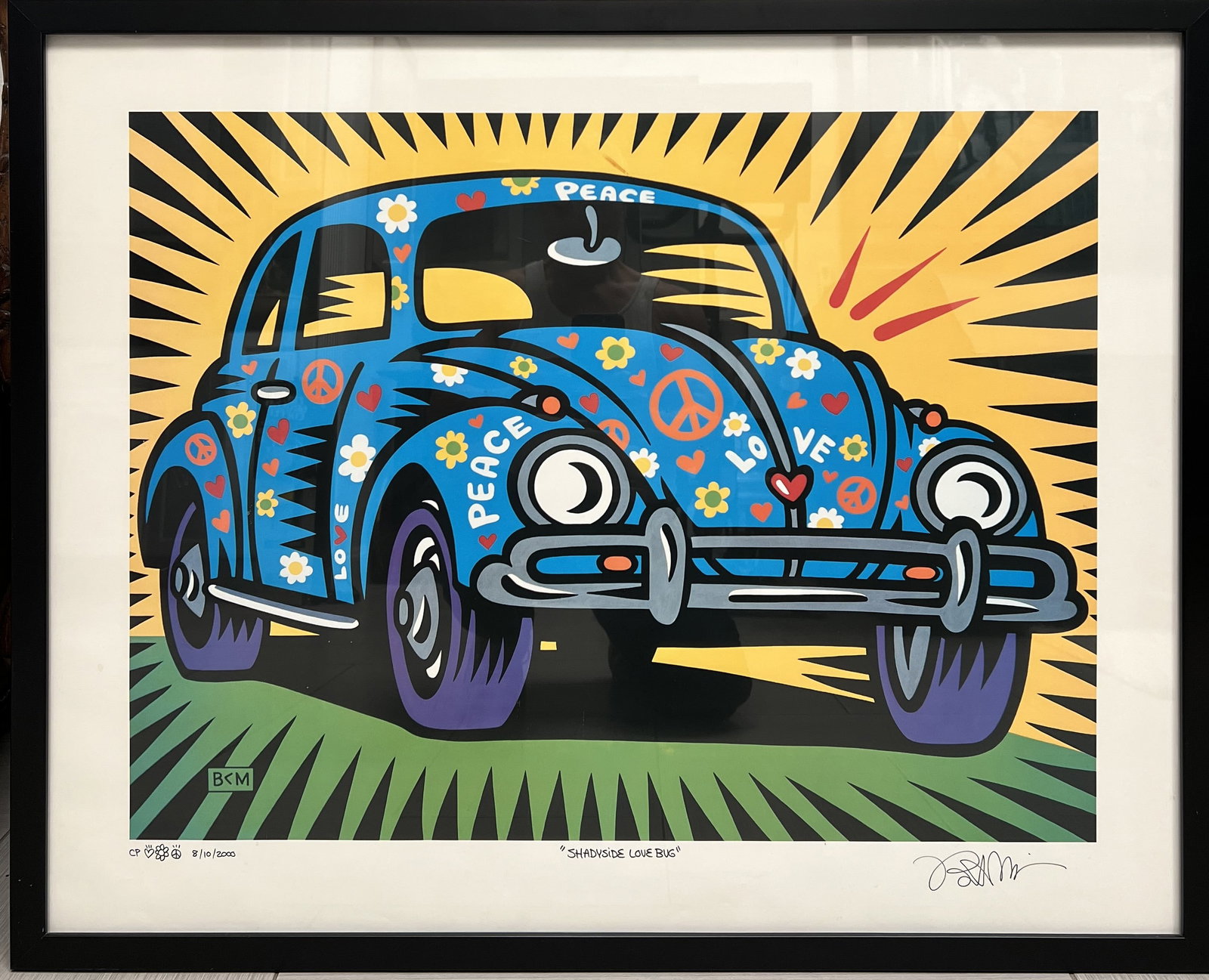 Burton Morris " Shadyside Love Bug" Framed Pop Art: The image displays a framed pop art print titled "Shadyside Love Bug" by American artist Burton Morris. The artwork features a vibrant, blue Volkswagen Beetle adorned with peace signs, hearts, and flo