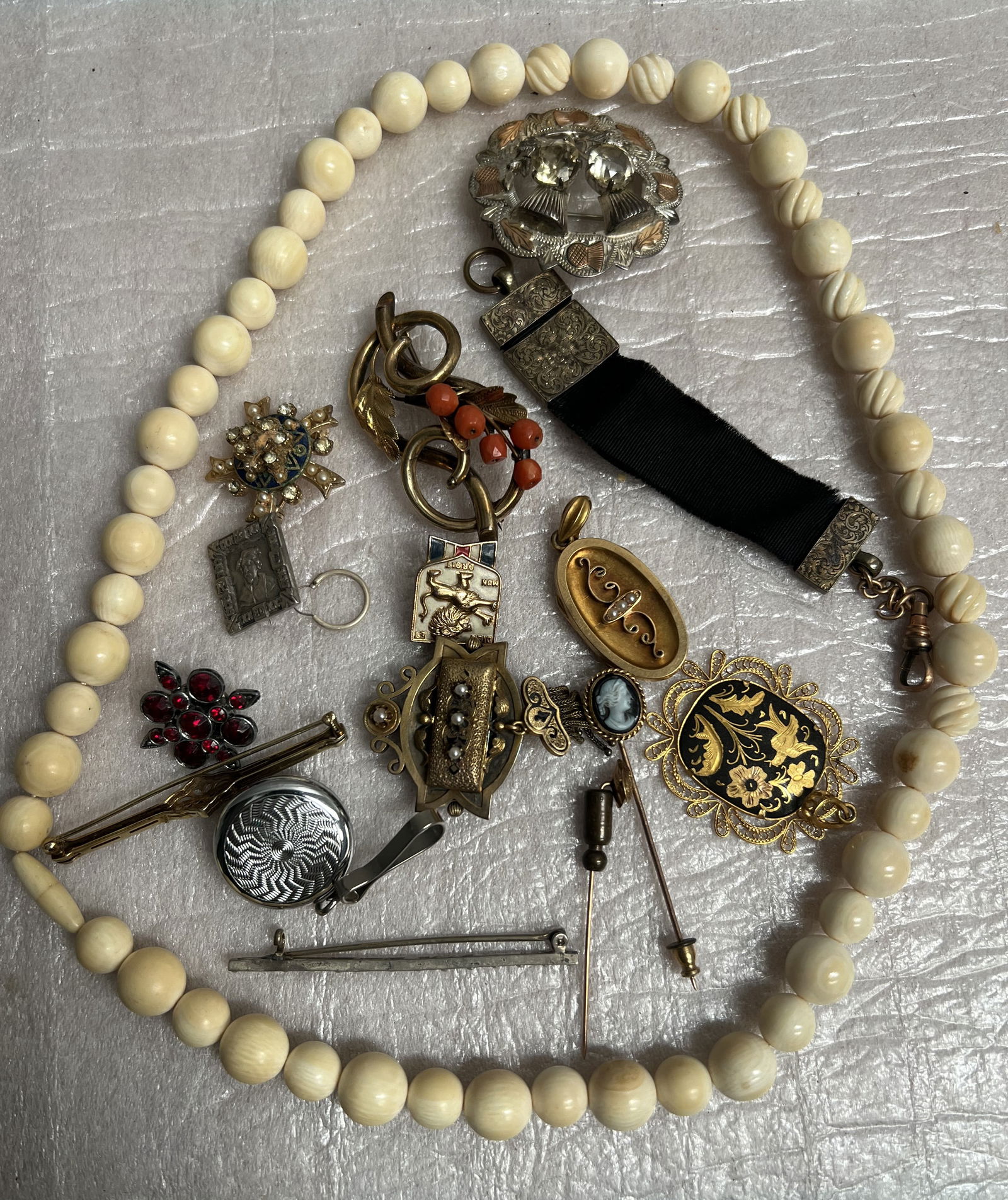 Collection of Assorted Vintage And Antique Jewelry: The image displays a collection of assorted vintage and antique jewelry pieces, likely a "convolut" or mixed lot, featuring various styles and materials. Beaded Necklace: A long necklace omposed of cr
