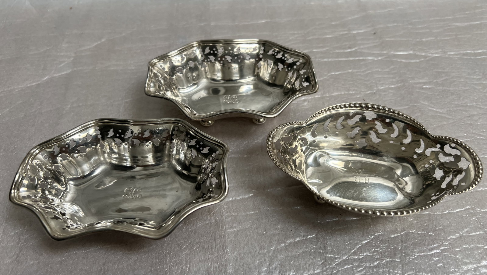 Set of 3 Tiffany & Co Sterling Silver Nut Dishes 4.2 oz: The items in the image are a set of three antique Tiffany & Co sterling silver nut dishes. Design: These dishes feature a distinct design with a delicately scalloped or octagonal edge and pierced (ret