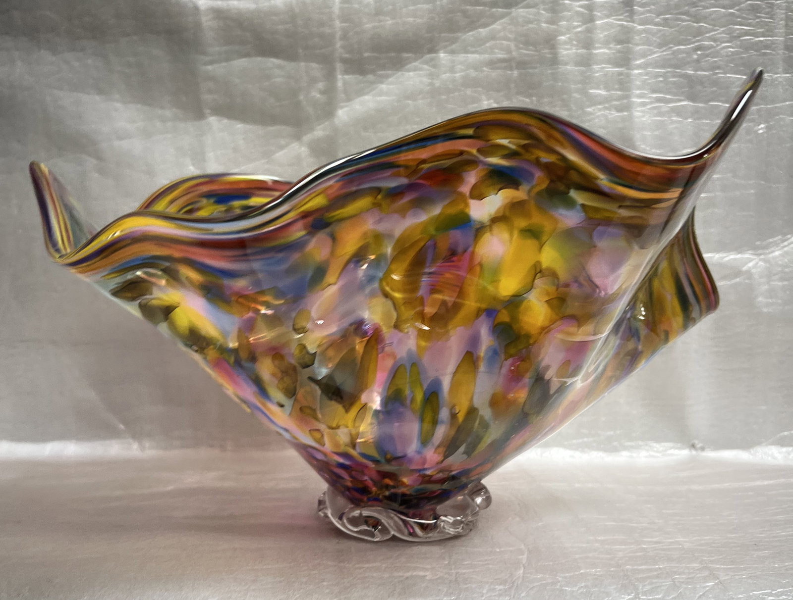 Hand-blown art glass bowl, vase, or centerpiece with a ruffled or fluted edge, signed: Purchased in a retail Chihuly store per the original owner. The object in the image is a hand-blown art glass bowl, vase, or centerpiece with a ruffled or fluted edge. Material and Technique: It is a 