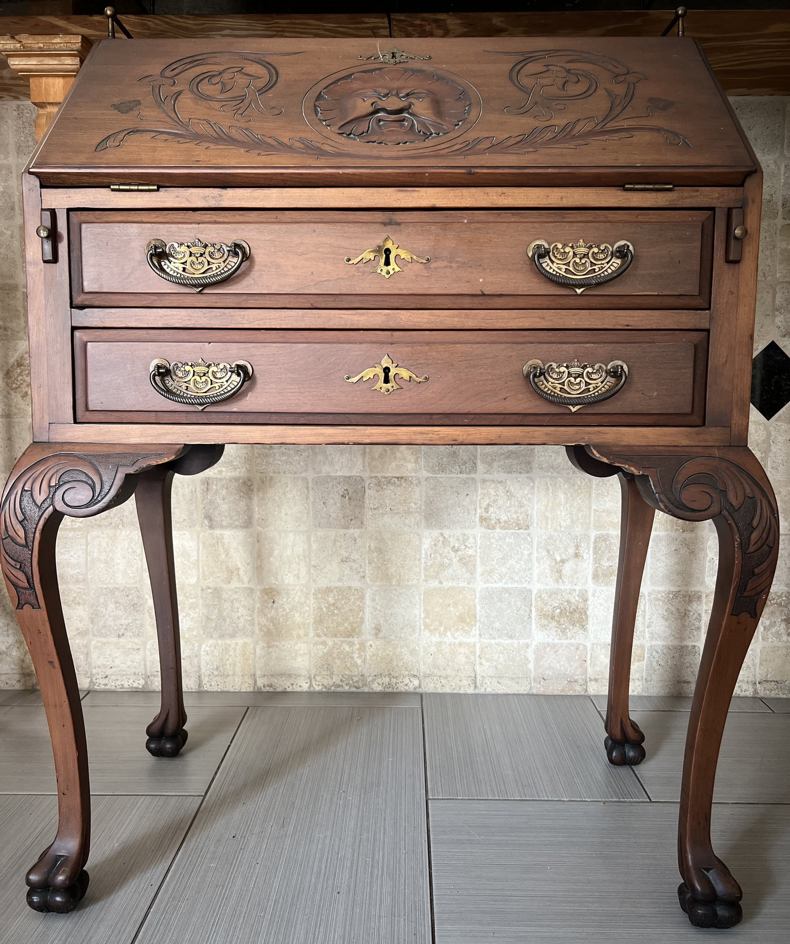 Antique Slant Front Deak Featuring Intricate Carvings and Distinct Style: he item pictured is an antique slant-front desk, also known as a bureau, featuring intricate carvings and a distinct style. Key features of the desk include: Material and Finish: The desk appears to b