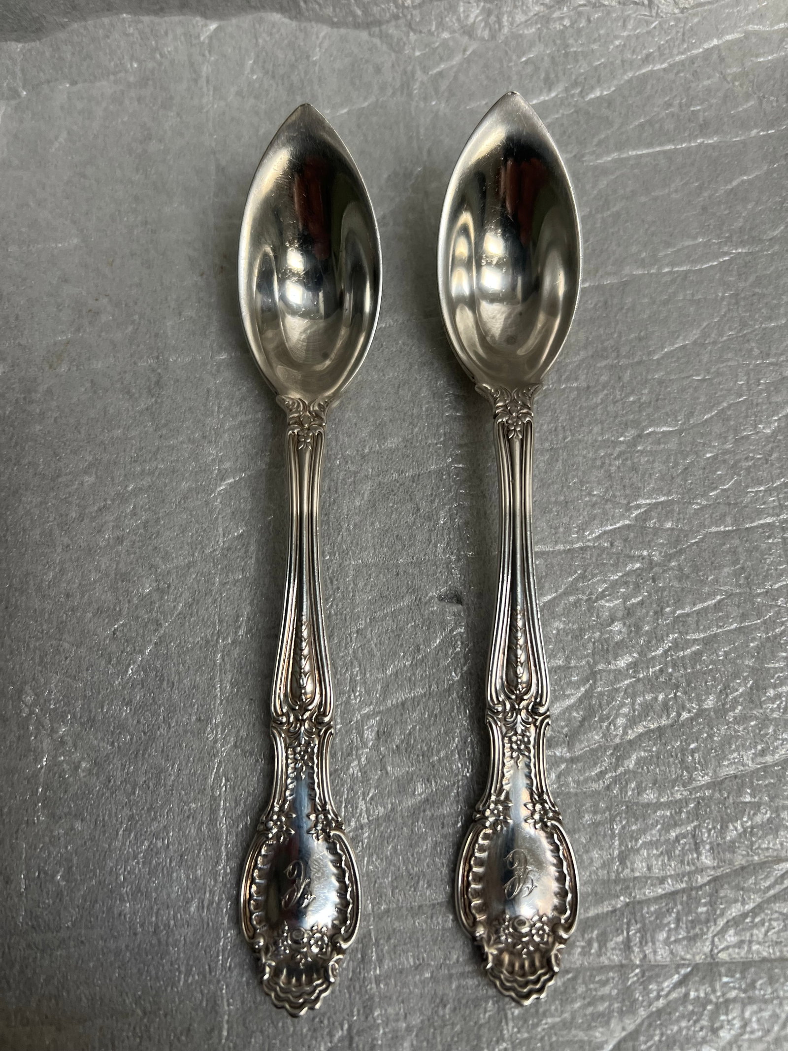Pair of Tiffany & Co Richeliue Sterling Silver Fruit or Orange Spoons: The image displays a set of two antique Tiffany & Co. Richelieu sterling silver fruit/orange spoons. The Richelieu pattern was introduced by Tiffany in 1892. The spoons feature an ornate, detailed han