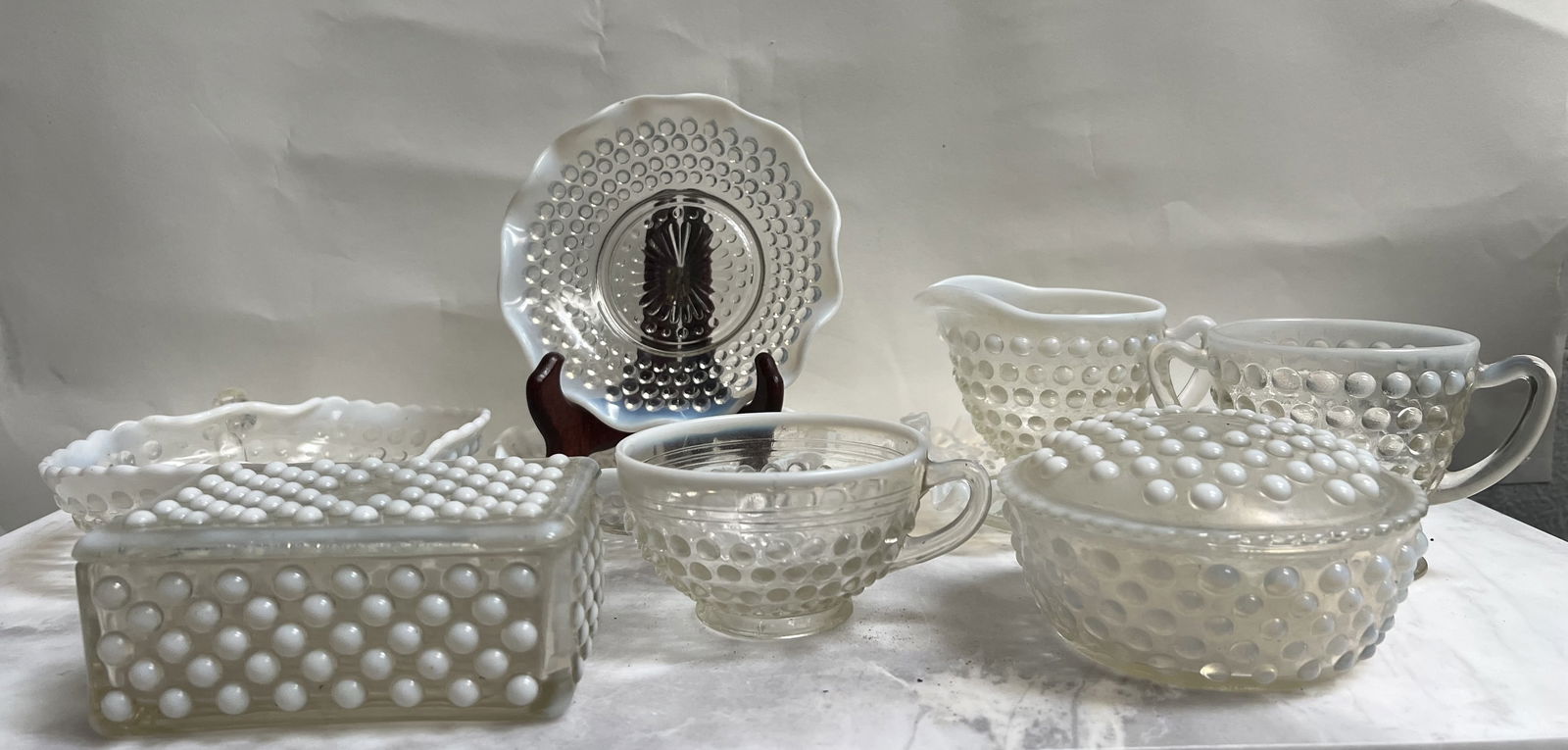 French Opalescent (Moonstone) collection: This stunning collection features seven pieces of vintage Fenton Hobnail glass. The set includes both French Opalescent (Moonstone) pieces, characterized by their translucent edges and milky white "ho