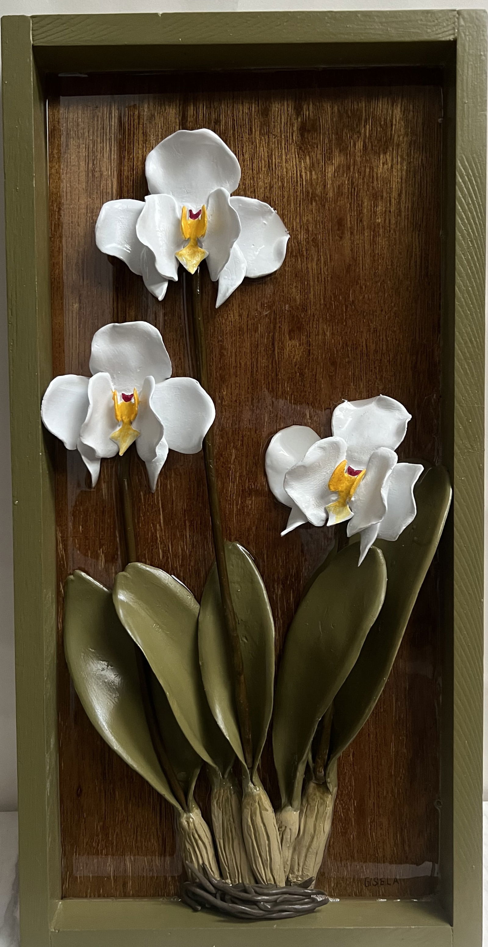 Gisela Pferdekamper Original 3D Ceramic Orchid Relief - 12x24 Signed Wood Panel: Artistic Description• Subject: A high-relief sculptural depiction of three White Orchids with vibrant yellow and pink centers.• Medium: Hand-formed ceramic elements mounted onto a rich, vert