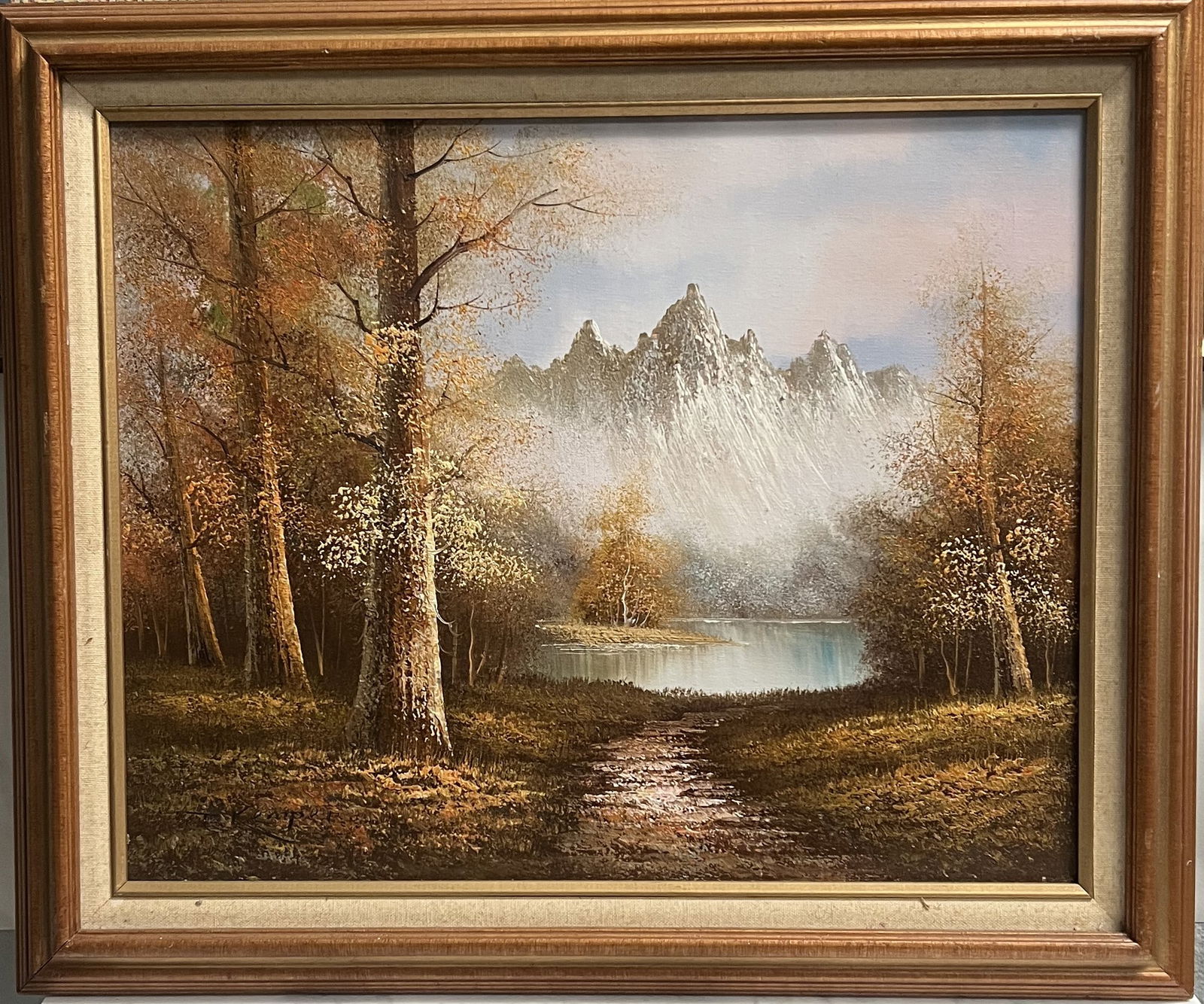 Mid-Century Modernist Mountain Landscape – Original Oil by T. Kemper: A serene and atmospheric original oil on canvas by artist T. Kemper. This work depicts a mist-shrouded mountain peak towering over a quiet woodland lake. The artist uses a warm, autumnal palette of ru