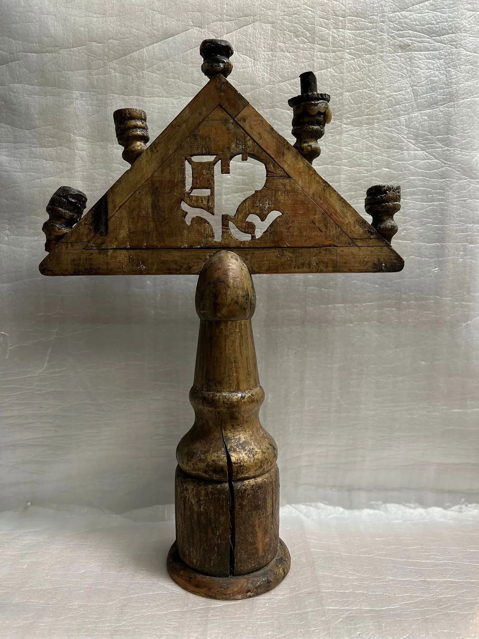 A hand-carved wooden altar candle holder from an Italian church, likely dating back to the 1600s: This is a 17th-century Italian wooden altar candle holder, triangular in form to symbolize the Trinity, with five candle sockets likely representing Christ’s wounds. It’s a rare survivor of early