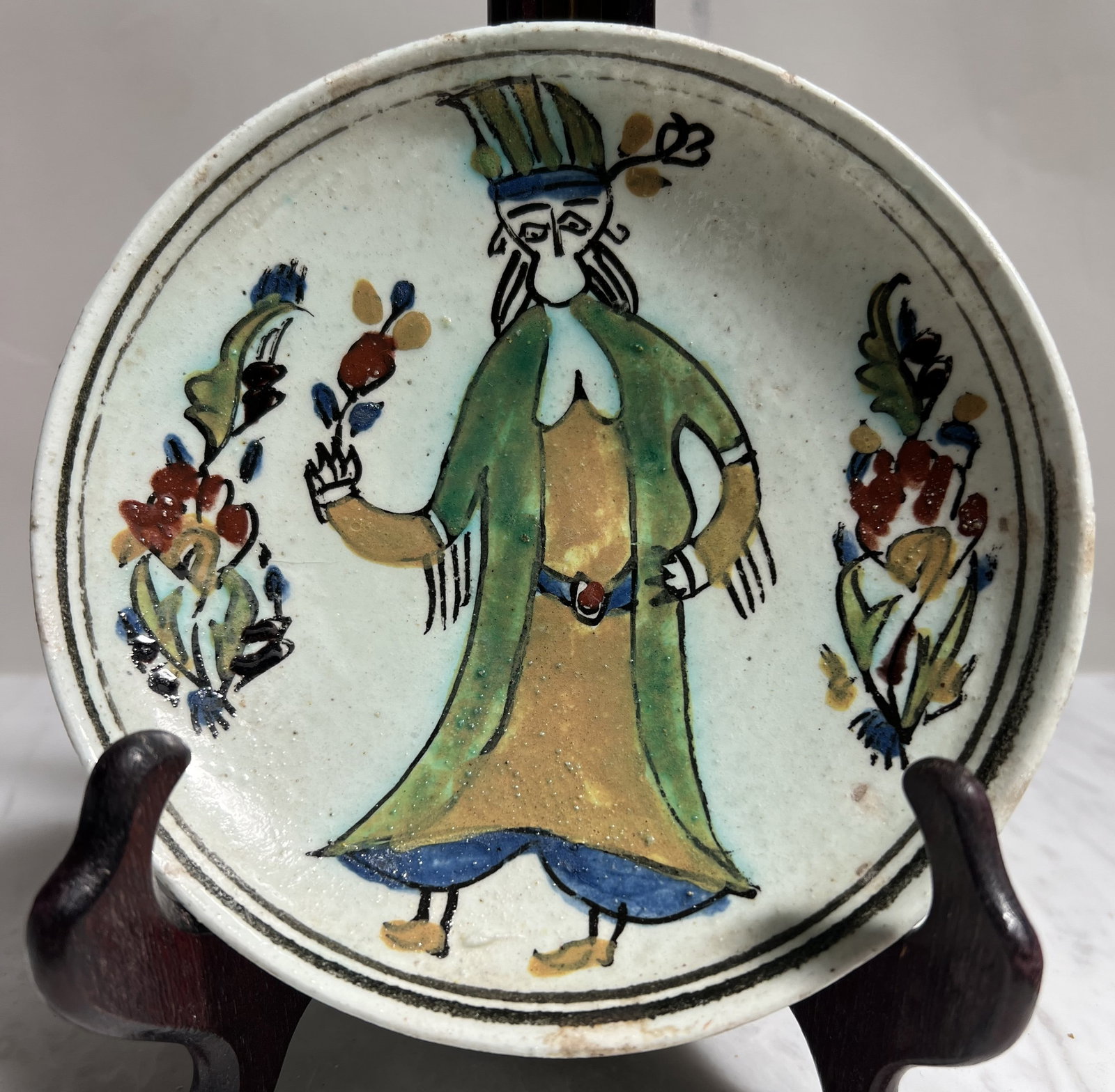 Antique Turkish Kütahya Hand-Painted Ceramic Plate – Figurative Ottoman Woman – 5.5”: • Origin: Kütahya, Turkey.• Style: Traditional Ottoman Folk Art / Iznik Revival.• Subject: Features a hand-painted central figure of a woman in a traditional green and ochre
