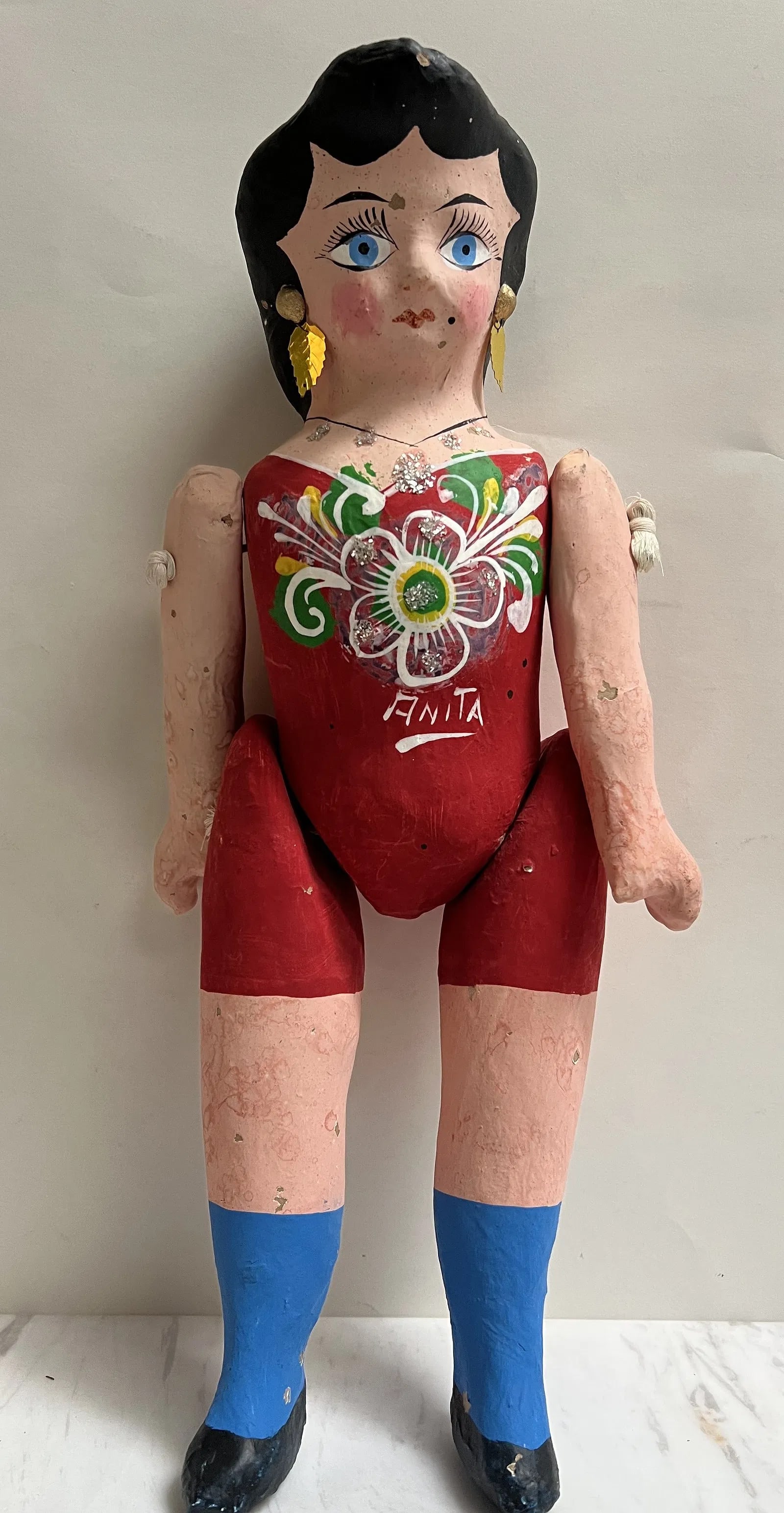 This 18-inch figurine is a traditional Mexican Lupita doll: This 18-inch figurine is a traditional Mexican Lupita doll, also known as a cartonería doll. These dolls are a significant form of Mexican folk art, handcrafted from a very hard type of papier-mâch�