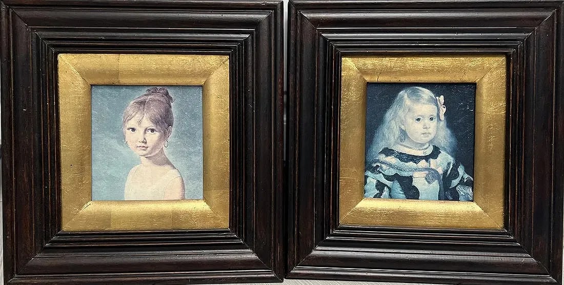Pair of 2 Smaller Framed Prints 12 x 12 each: Details of the Prints:Subjects: The left painting features a young girl with her hair styled in an updo, looking directly forward against a light blue background. The right painting depicts a younger 