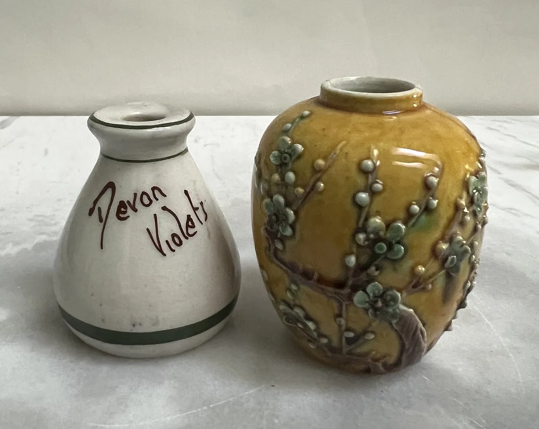 Pair of Vintage Miniature Jars: English Torquay 'Devon Violets' Scent Bottle & Chinese Yellow Prunus: A charming duo of vintage ceramic miniatures, featuring a hand-painted English souvenir bottle and a textured Chinese export jar. Both stand approximately 2.5” tall.1. Vintage Torquay Pottery "D