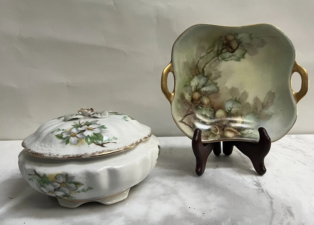Vintage Porcelain Trinket Set: Dogwood Covered Bowl & German Handled Floral Dish": These two vintage porcelain pieces represent classic mid-20th-century decorative giftware, likely originating from export potteries in Japan or Germany.1. Vintage "Dogwood" Covered Trinket Bowl• 