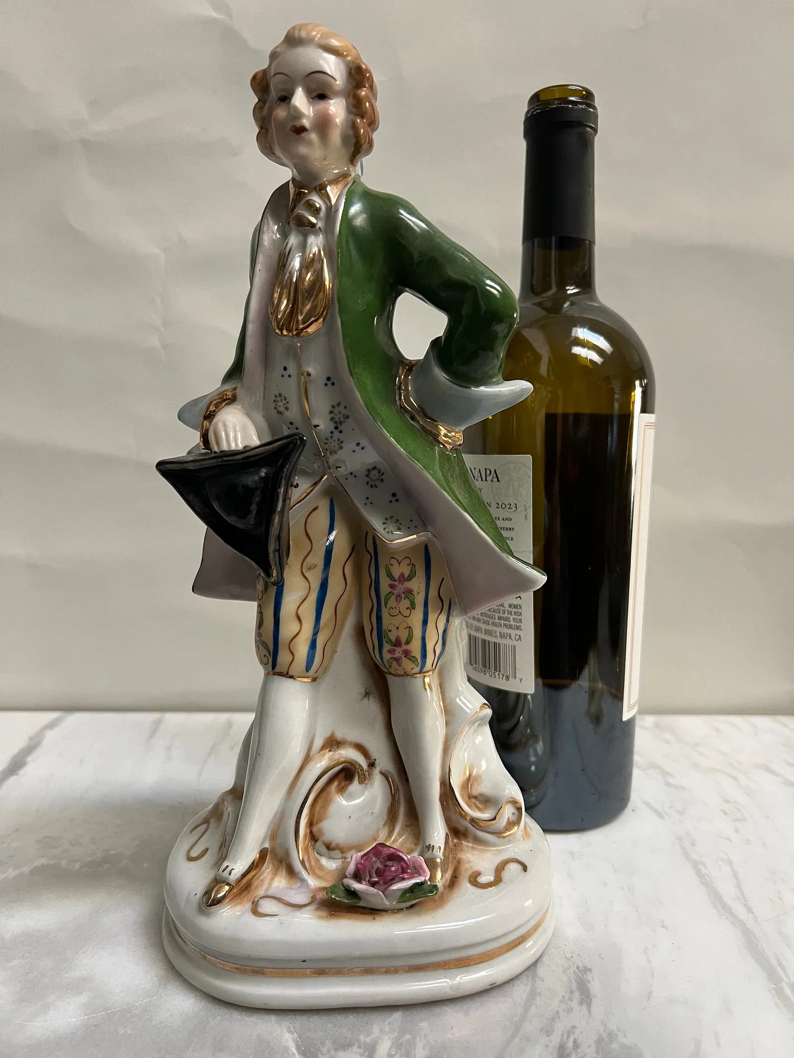"Vintage 11” Colonial Gentleman Porcelain Statue – Hand-Painted Green Frock Coat": This 11-inch tall statue is a vintage porcelain figurine of an 18th-century Colonial or Victorian gentleman, likely manufactured in Japan or during the Occupied Japan period (1945–1952).Description 