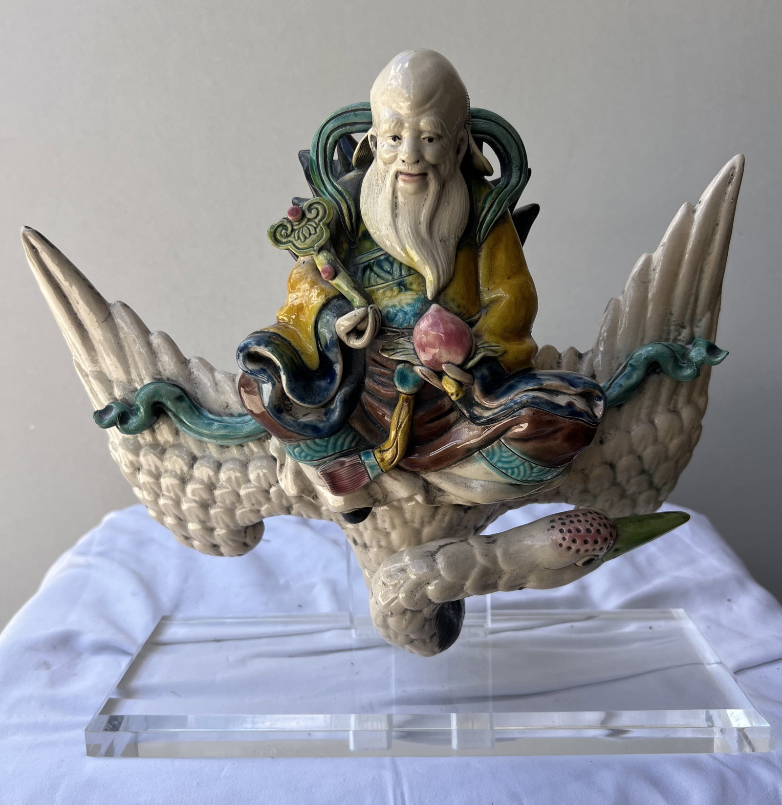 A Chinese Shiwan Polychrome Glazed Pottery Figure of Shoulao (God of Longevity) Riding a Crane Circ: Subject Matter: The sculpture depicts Shoulao (or Shou Xing), the popular Daoist stellar deity of longevity and good health. He is immediately recognizable by his signature high, domed cranium, long w