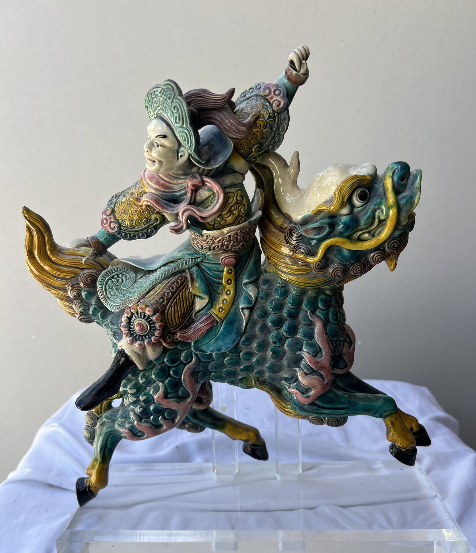 Chinese Shiwan Sancai Glazed Figurine of a Warrior Riding a Qilin: Subject & Style: This is a dynamic Chinese ceramic sculpture depicting a legendary warrior or deity in full armor, dynamically mounted on a galloping Qilin (mythical hooved beast). It is executed in t