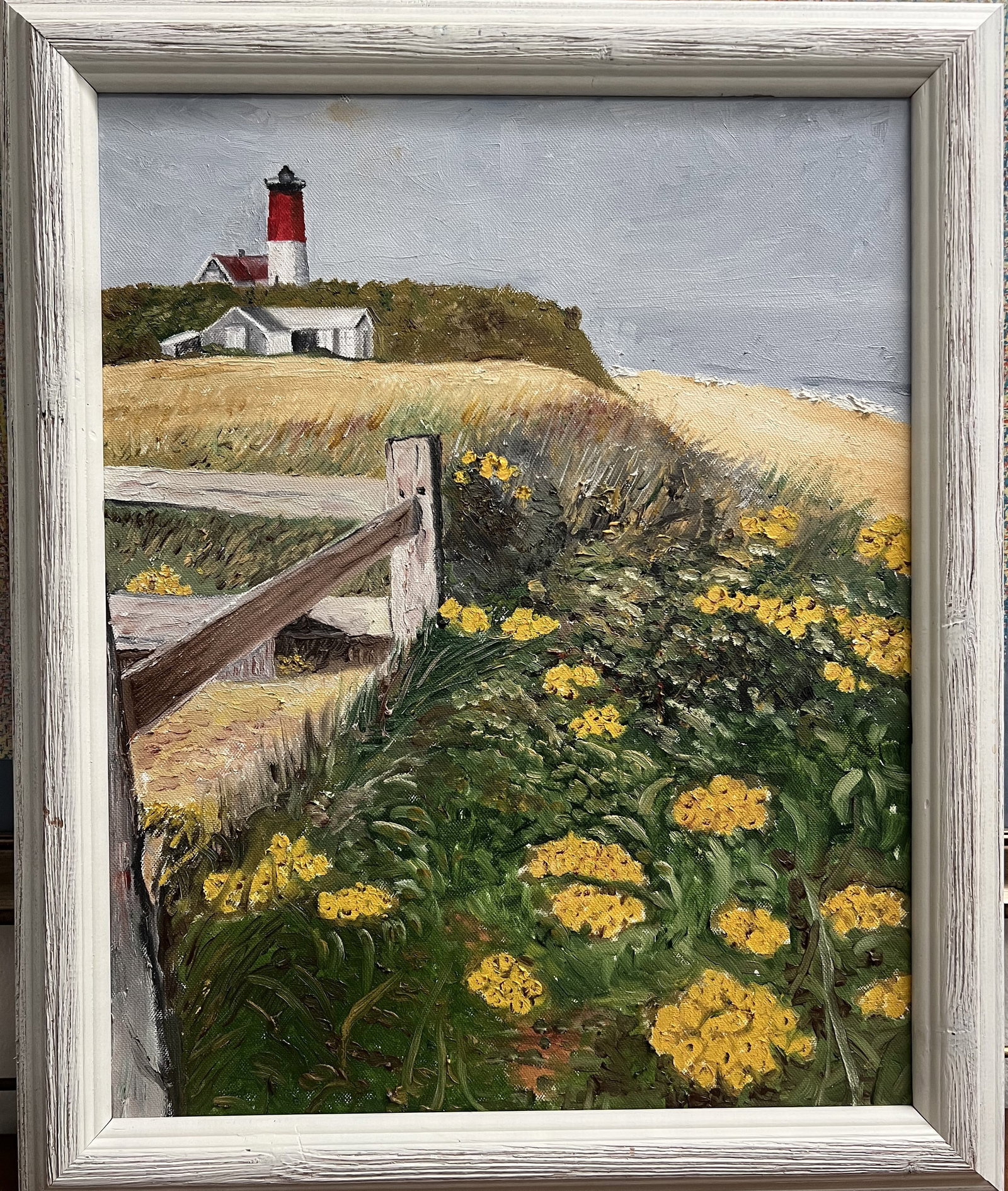 Vintage Coastal Lighthouse Oil Painting on Canvas by Art Krug – Framed 23" x 19": This original oil on canvas painting by Art Krug features a coastal landscape depicting a classic red-and-white top lighthouse perched atop a grassy bluff overlooking the sea. The foreground is filled