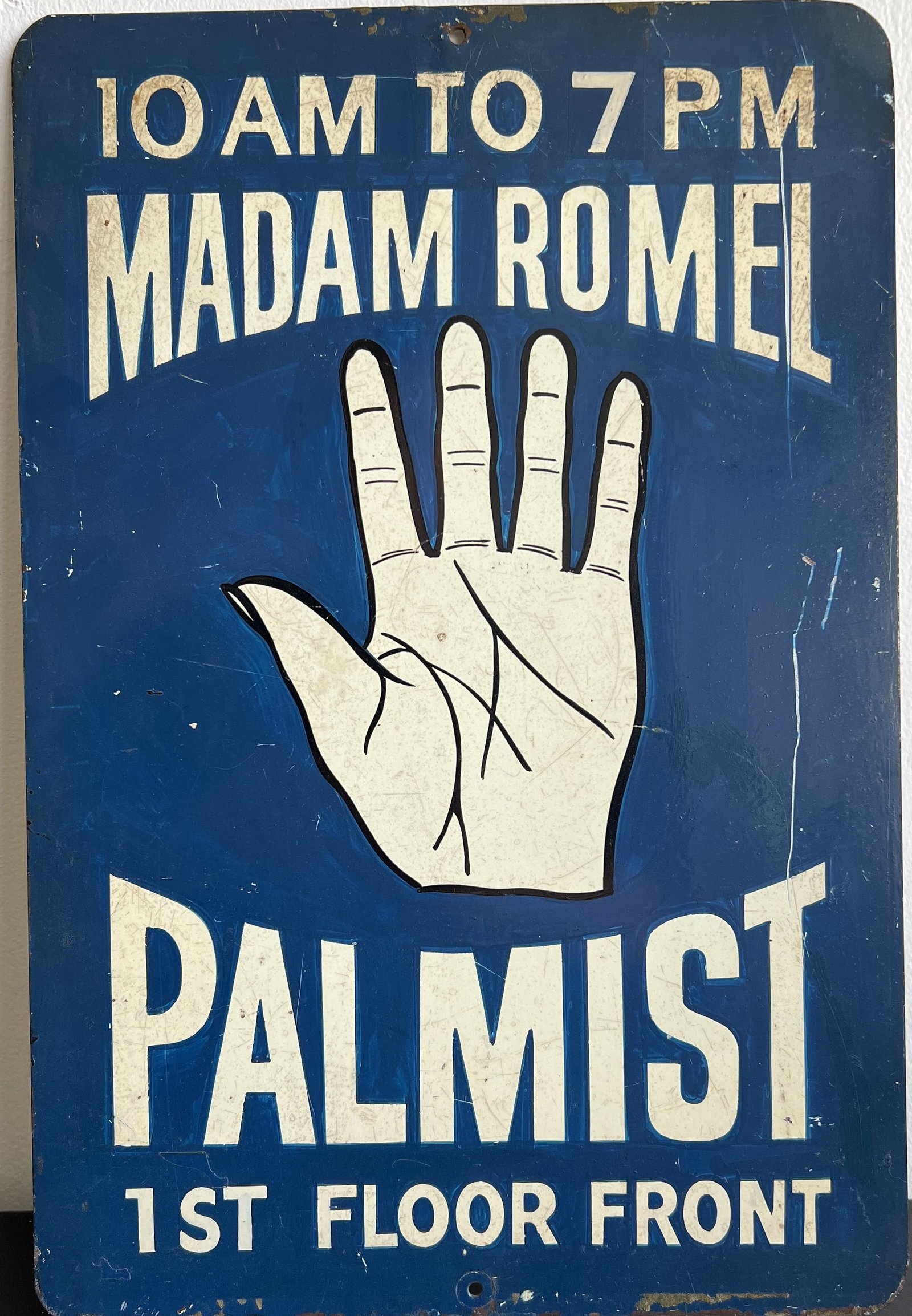 This vintage, single-sided rectangular trade sign advertises a palm reader's services, featuring bol: This vintage, single-sided rectangular trade sign advertises a palm reader's services, featuring bold graphics and classic typography. Front Design: Features off-white text over a deep blue background