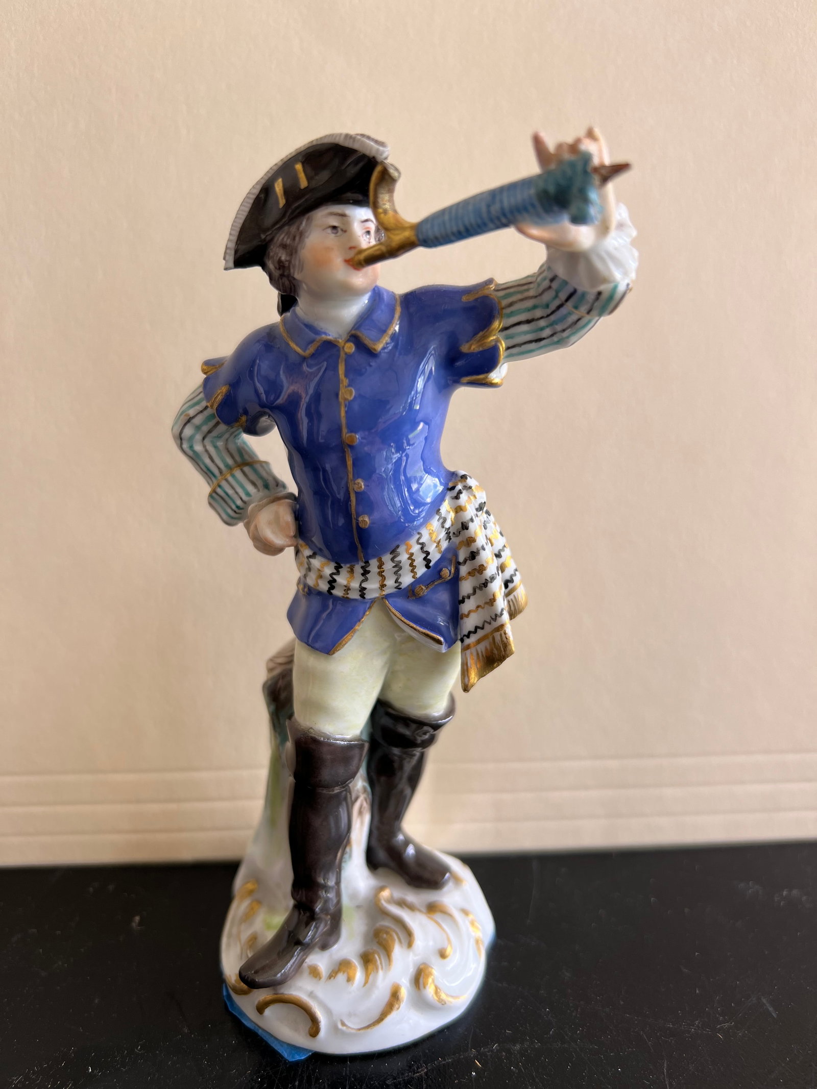 Vintage Dresden German Porcelain Figurine 6" – Postrider / Postillion blowing Horn: This fine 6-inch hand-painted porcelain figurine depicts an 18th-century European postrider or postillion blowing a post horn. Attribution & Marks: Features an underglaze blue crossed-swords style mar