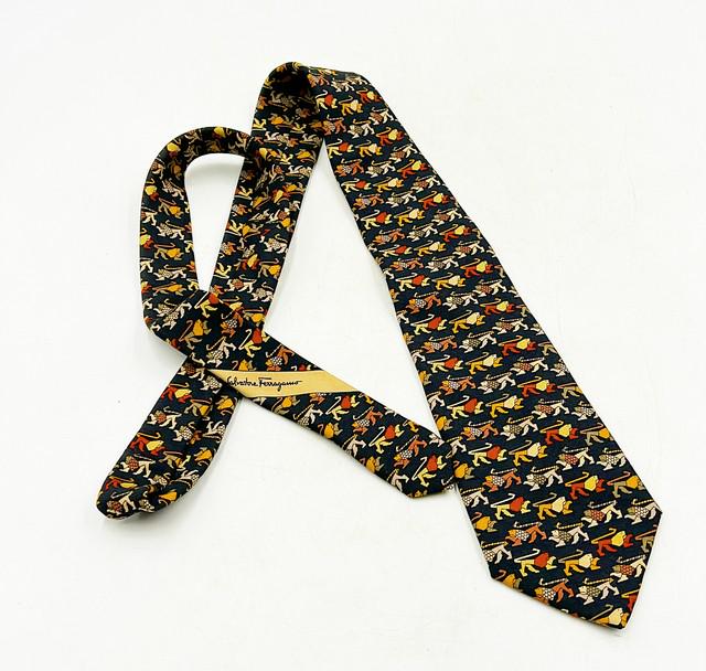 Vintage Salvadore Ferragamo mens necktie.: Vintage Salvadore Ferragamo mens necktie. 100% silk made in Italy. Original labels in tact. Black background with multi-colored lion figure print. Approx 56Ó long x 3Ó wide.