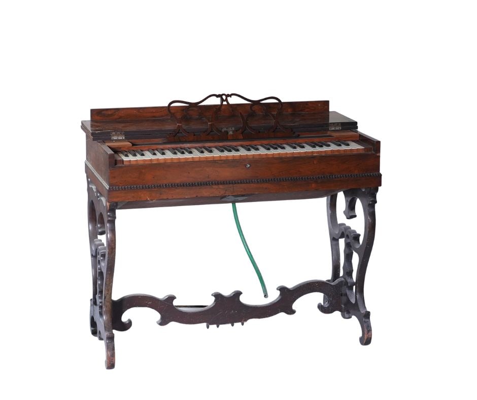 19th Century American Rosewood Folding Melodeon: An American rosewood folding melodeon, the rectangular case with a hinged top opens to reveal a keyboard above a molded border. Raised on a scroll-carved trestle base. Circa date 1830