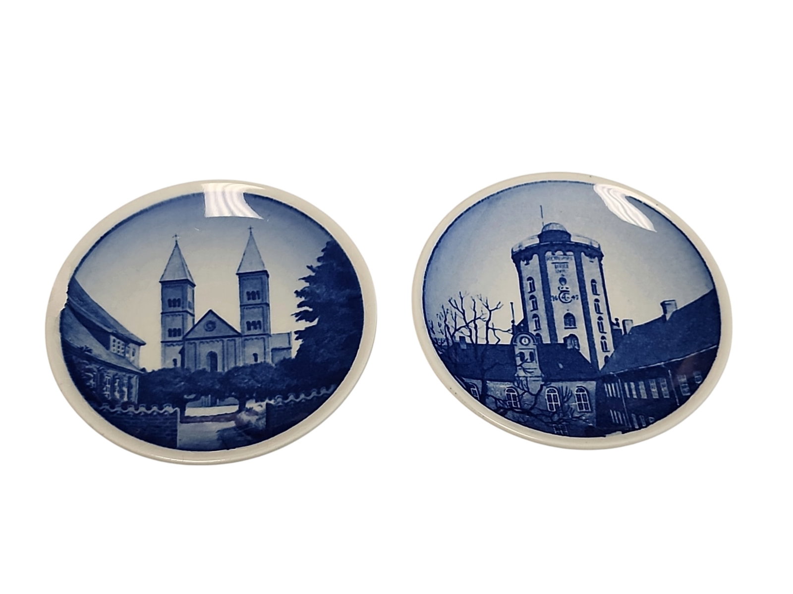 Vintage Pair of Royal Copenhagen Faience Plaquettes: Lovely pair of vintage Royal Copenhagen Faience plaquettes, circa 1969+, one with small chip to rim, other with no blemishes.One of Viborg Cathedral #19, one of Round Tower #8, both designed by and be