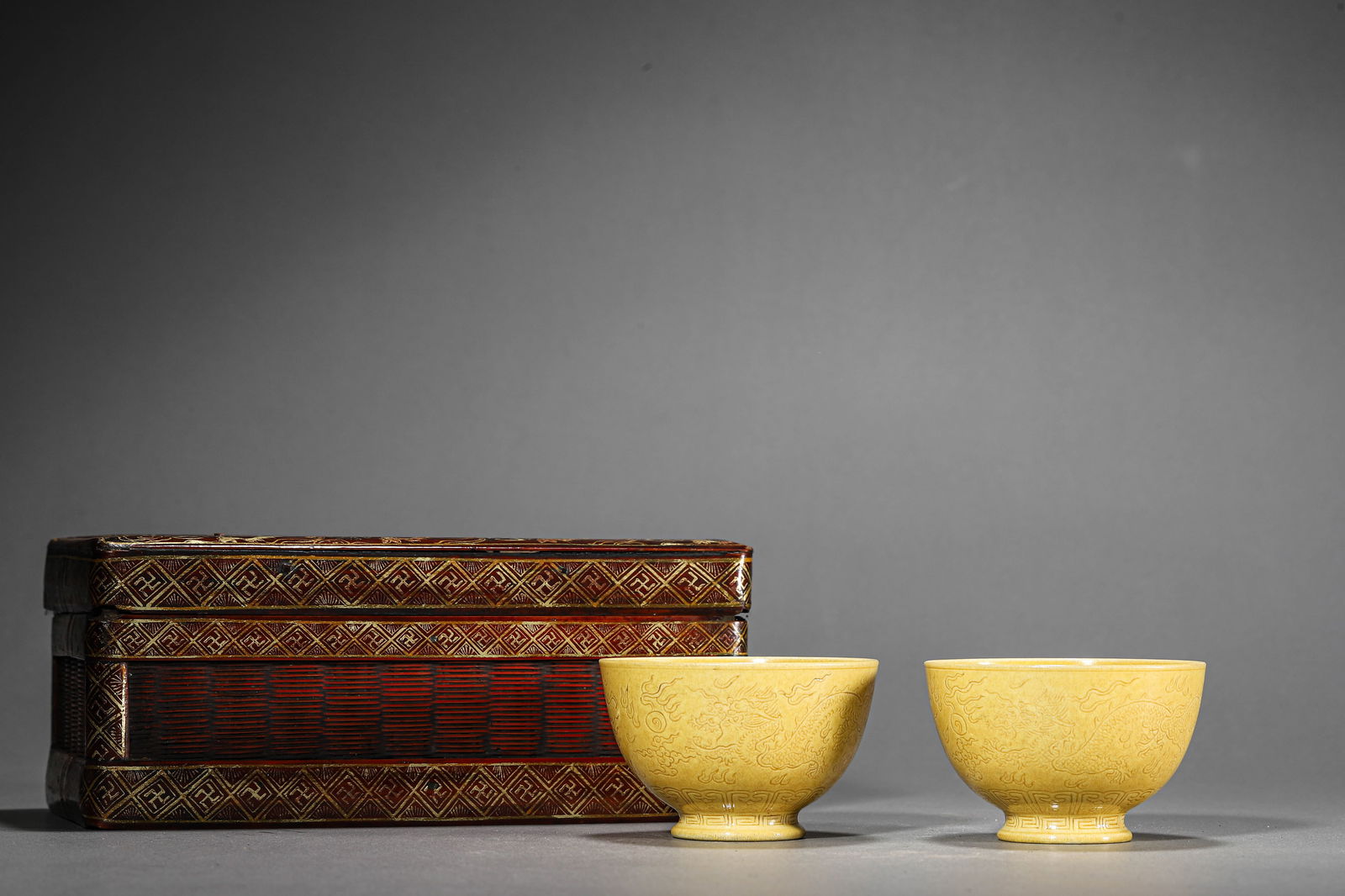 A CHINESE YELLOW-GLAZED CUP WITH INCISED DRAGON MOTIFS, MARKED "DA QING QIANLONG NIANZHI," POSSIBLY: A CHINESE YELLOW-GLAZED CUP WITH INCISED DRAGON MOTIFS, MARKED "DA QING QIANLONG NIANZHI," POSSIBLY QING DYNASTY, 18TH CENTURY. Diameter: 3 1/16 in. (7.7 cm), Height: 1 15/16 in. (5 cm)