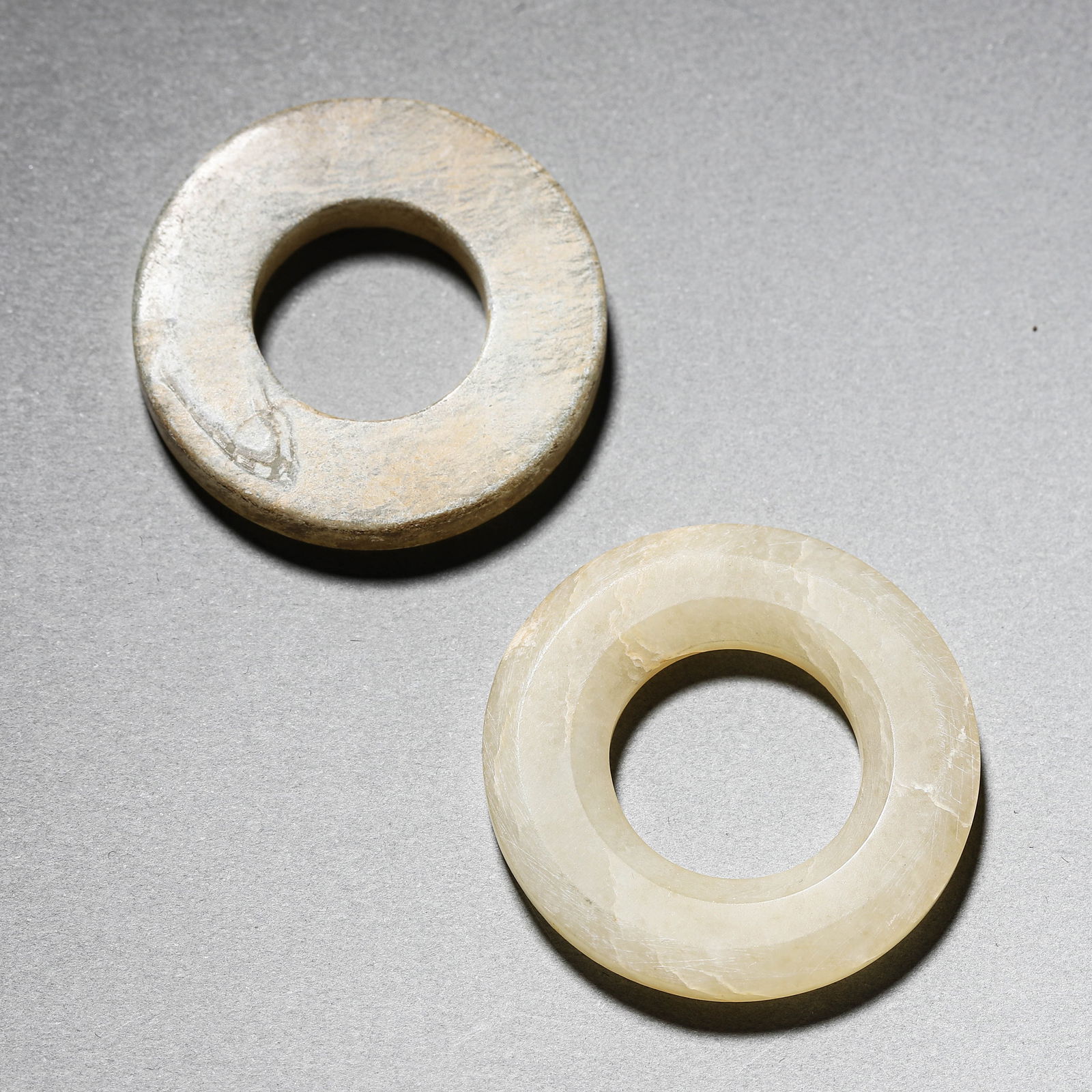 A PAIR OF CHINESE JADE RINGS.: A PAIR OF CHINESE JADE RINGS. Dimensions: Diameter: 1 7/16 in. (3.6 cm) ALL ITEMS SOLD AS IS, NO RETURNS Condition: Any statement made in any catalogue or otherwise regarding the origin, d