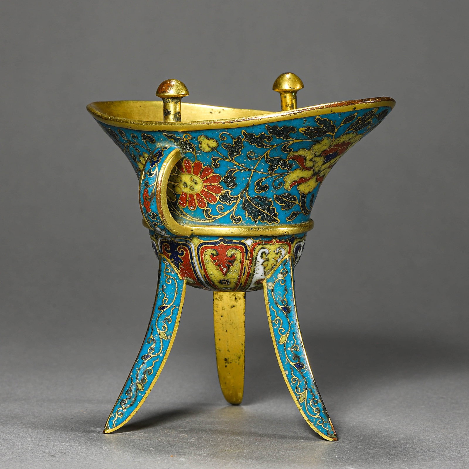 A CHINESE CLOISONNÉ ENAMEL JUE CUP, MARKED "JINGTAI NIAN ZHI," POSSIBLY MING DYNASTY, 15TH CENTURY.: A CHINESE CLOISONNÉ ENAMEL JUE CUP, MARKED "JINGTAI NIAN ZHI," POSSIBLY MING DYNASTY, 15TH CENTURY. Dimensions: Length: 4 5/16 in. (11 cm), Height: 4 3/4 in. (12 cm) ALL ITEMS SOLD AS IS, NO RETURNS