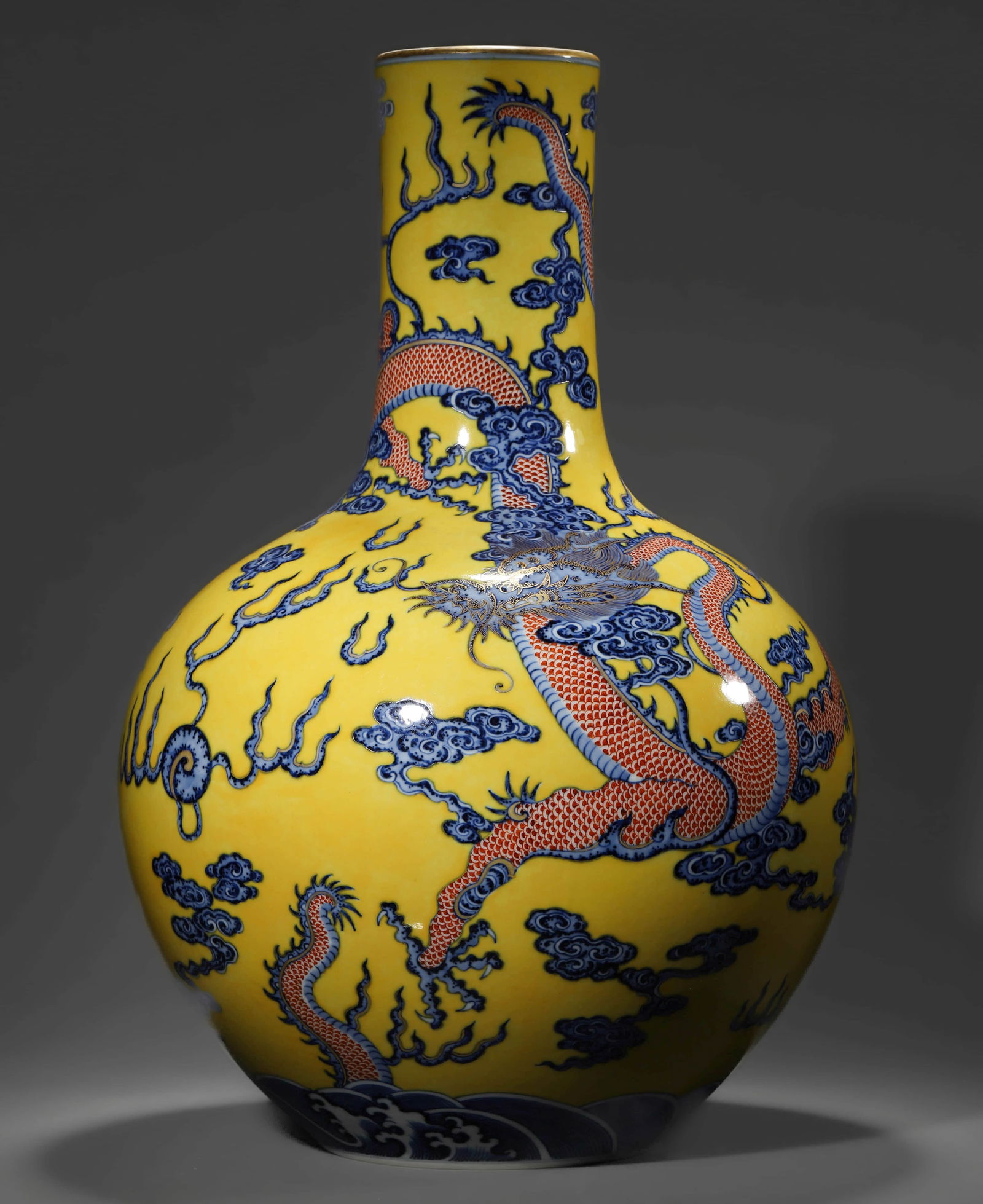 A CHINESE YELLOW-GROUND BLUE AND IRON RED BOTTLE VASE WITH CLOUD AND DRAGON MOTIFS.: A CHINESE YELLOW-GROUND BLUE AND IRON RED BOTTLE VASE WITH CLOUD AND DRAGON MOTIFS. Dimensions: Height: 18 7/8 in. (48 cm) ALL ITEMS SOLD AS IS, NO RETURNS Condition: Any statement made in