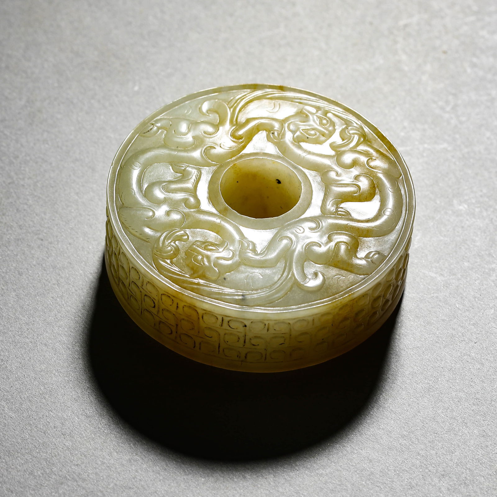 A CHINESE WHITE JADE DISC WITH CHI-TIGER MOTIFS.: A CHINESE WHITE JADE DISC WITH CHI-TIGER MOTIFS. Dimensions: Diameter: 2 3/16 in. (5.5 cm), Height: 13/16 in. (2 cm) ALL ITEMS SOLD AS IS, NO RETURNS Condition: Any statement made in any catalogue