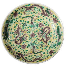 A CHINESE YELLOW-GROUND DISH WITH POLYCHROME DRAGON AND PHOENIX DESIGN, MARKED "DA QING KANGXI NIAN (1 of 3)