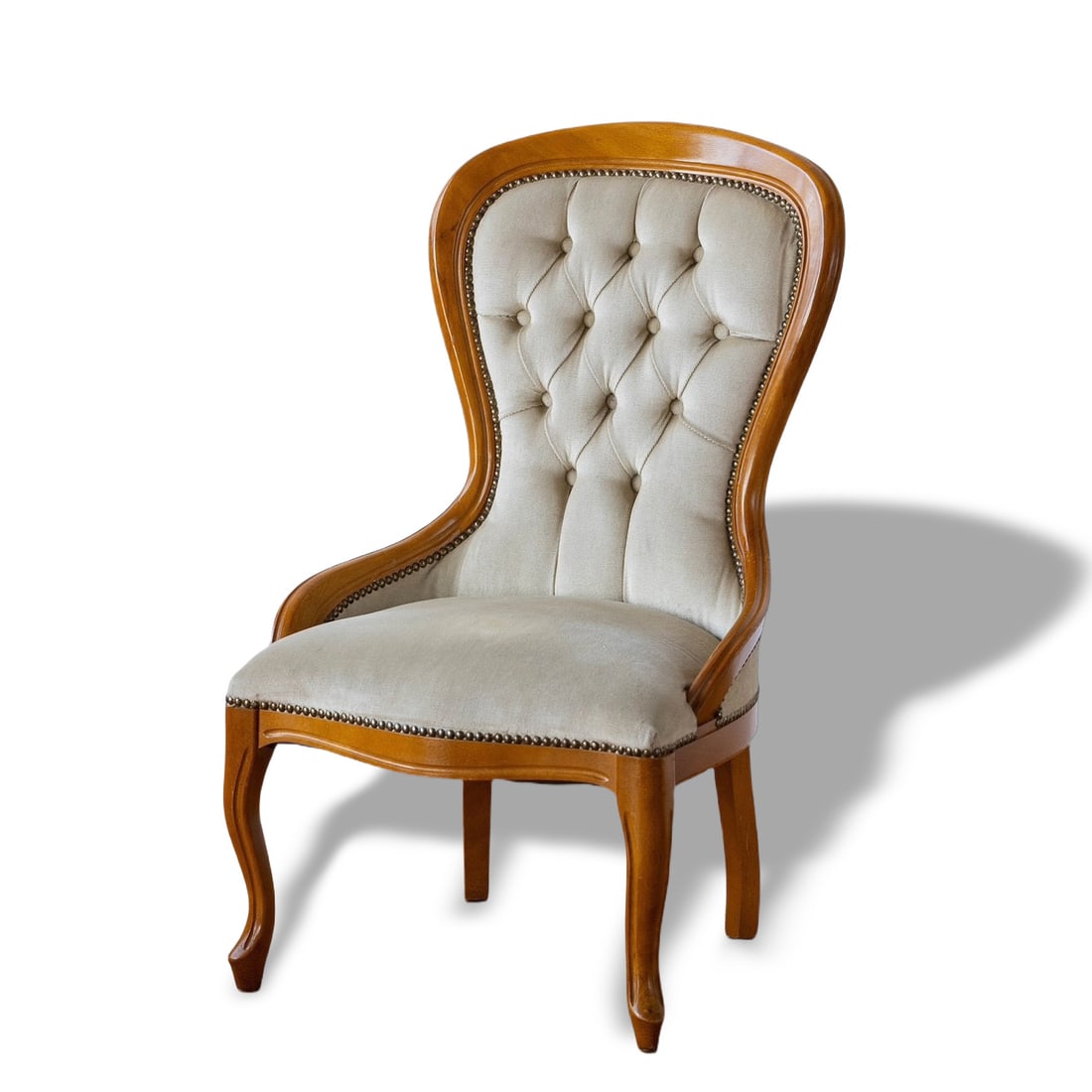1940S BRITISH ANTIQUE ARMCHAIR: 88 cm x 57 cm x 55 cm (34 5/8 in x 22 1/2 in x 21 5/8 in) This is a 1940s British antique armchair featuring a button-tufted backrest with graceful, flowing lines. The wooden frame has a natural wood