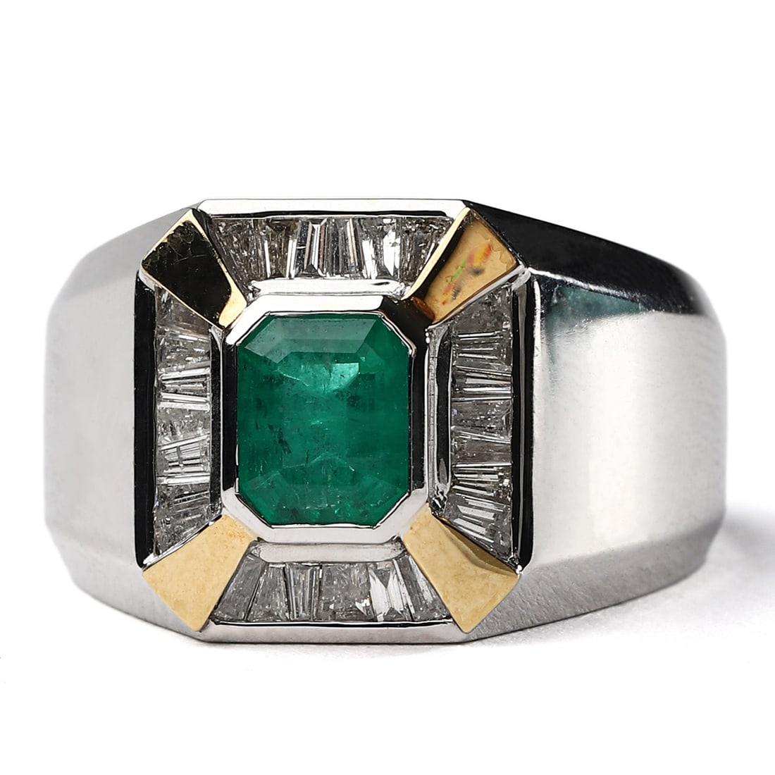 A WHITE GOLD, YELLOW GOLD, EMERALD AND DIAMOND RING: Dimensions: Ring size approx. 17.7 mm (interior diameter); Face: 8.3 × 6.4 mm; Weight: 6.6 g Description: A bold, geometric ring featuring a step-cut emerald of vivid green hue, framed by a border of