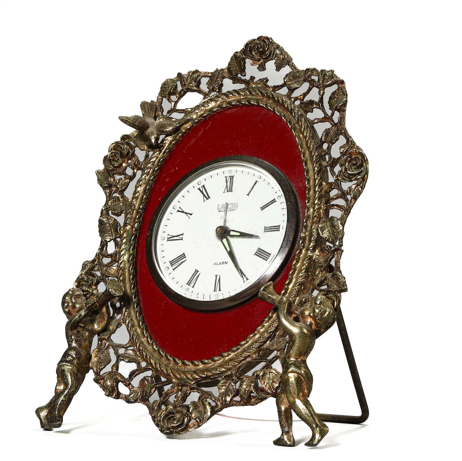 A JAPANESE GILT METAL TABLE CLOCK WITH CHERUB FRAME: Dimensions Length: 6 1/4 in (16 cm), Width: 4 1/2 in (11.5 cm) Description The oval clock is encased in a pierced gilt metal frame with floral motifs, surmounted by birds and supported by two cherubs.