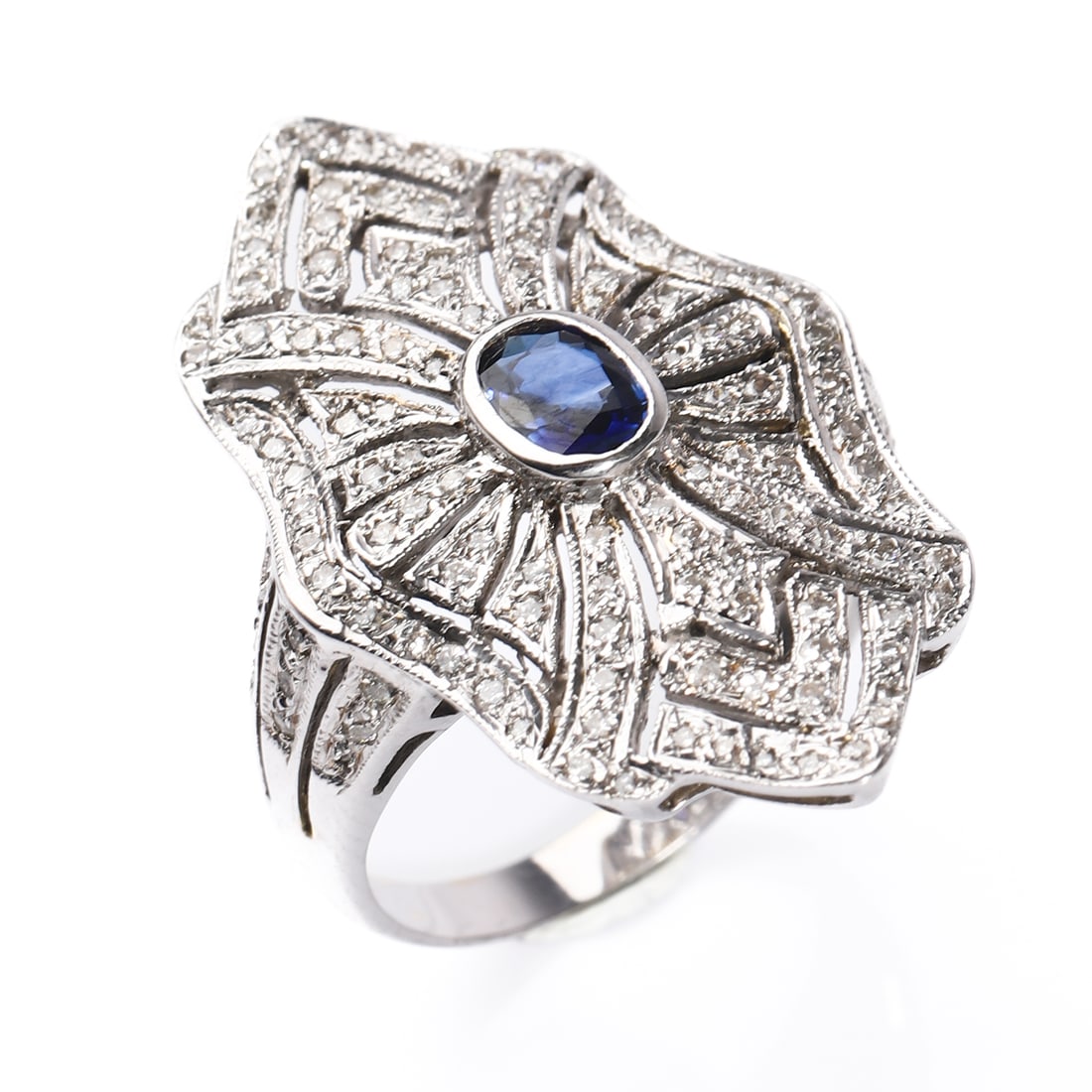 RETRO 18K WHITE GOLD SAPPHIRE AND DIAMOND RING: Dimensions Inner diameter: 11/16 in (17.4 mm); Weight: 7.1 g Description A Retro period 18k white gold sapphire and diamond ring, featuring an oval-cut sapphire weighing approximately 0.56 carat at th