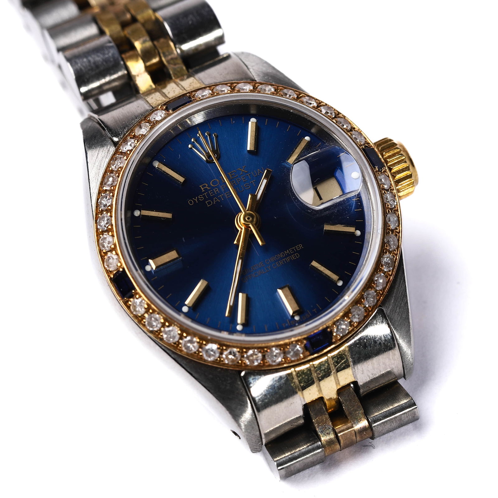 ROLEX OYSTER PERPETUAL DATEJUST LADIES WATCH: This elegant Rolex Oyster Perpetual Datejust ladies watch features a striking deep blue dial encased in stainless steel and gold, beautifully accented by a bezel set with diamonds and sapphires. It sh