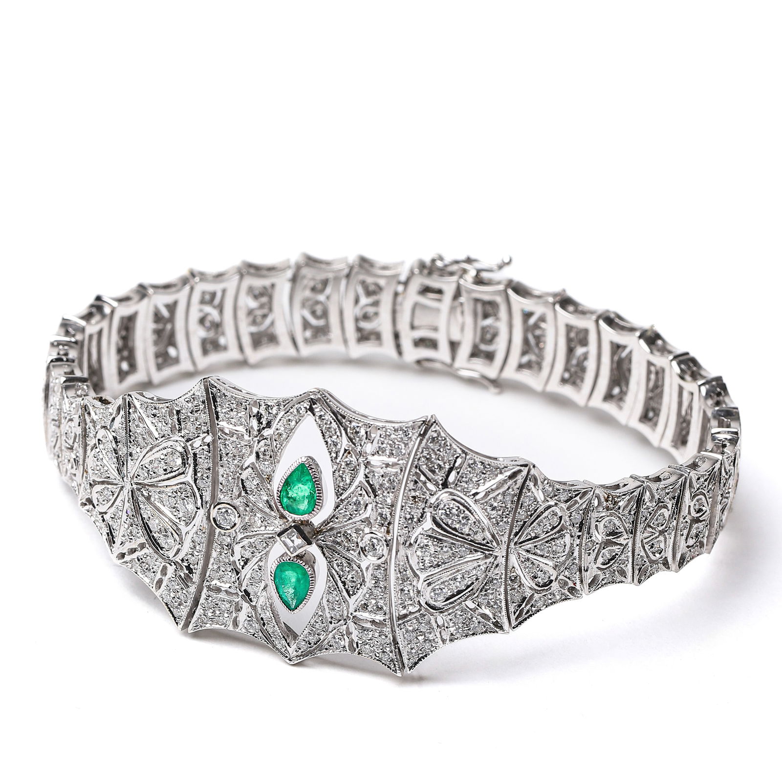ART DECO ITALIAN CUSTOM 18K GOLD BRACELET SET WITH DIAMONDS AND EMERALDS, 1925-1935.: Dimensions: Length: 7 1/2 in (19 cm); Weight: 37.7 g; Period: 1925-1935.This custom-made bracelet is meticulously crafted from 18k white gold, featuring the iconic beaded edge detailing of the Art Dec