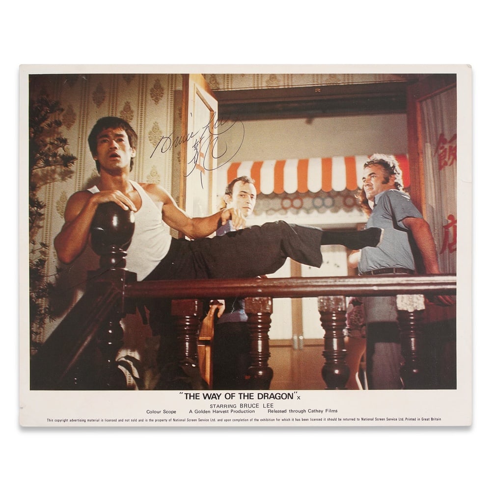 BRUCE LEE SIGNED "THE WAY OF THE DRAGON" UK LOBBY CARD: 10 x 8 1/8 in (25.5 x 20.5 cm) Provenance and Authentication: This collectible has undergone a rigorous forensic evaluation. The signatures were carefully analyzed across multiple criteria, including 