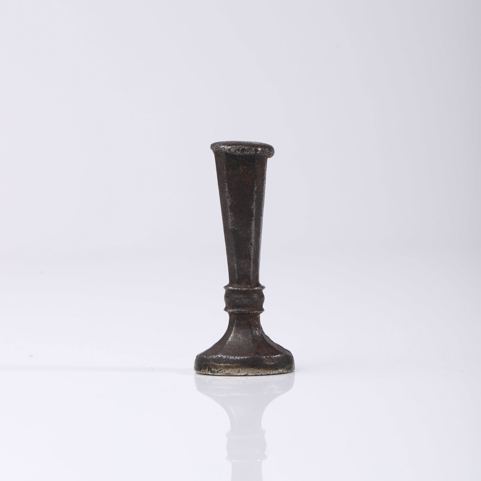 A BRONZE HERALDIC SEAL: Dimensions Height 1 3/4 in (4.5 cm); Weight 29.4 g. Description A bronze seal with a tapered cylindrical handle rising from a rounded base, showing an aged dark patina. The seal matrix is engraved wit