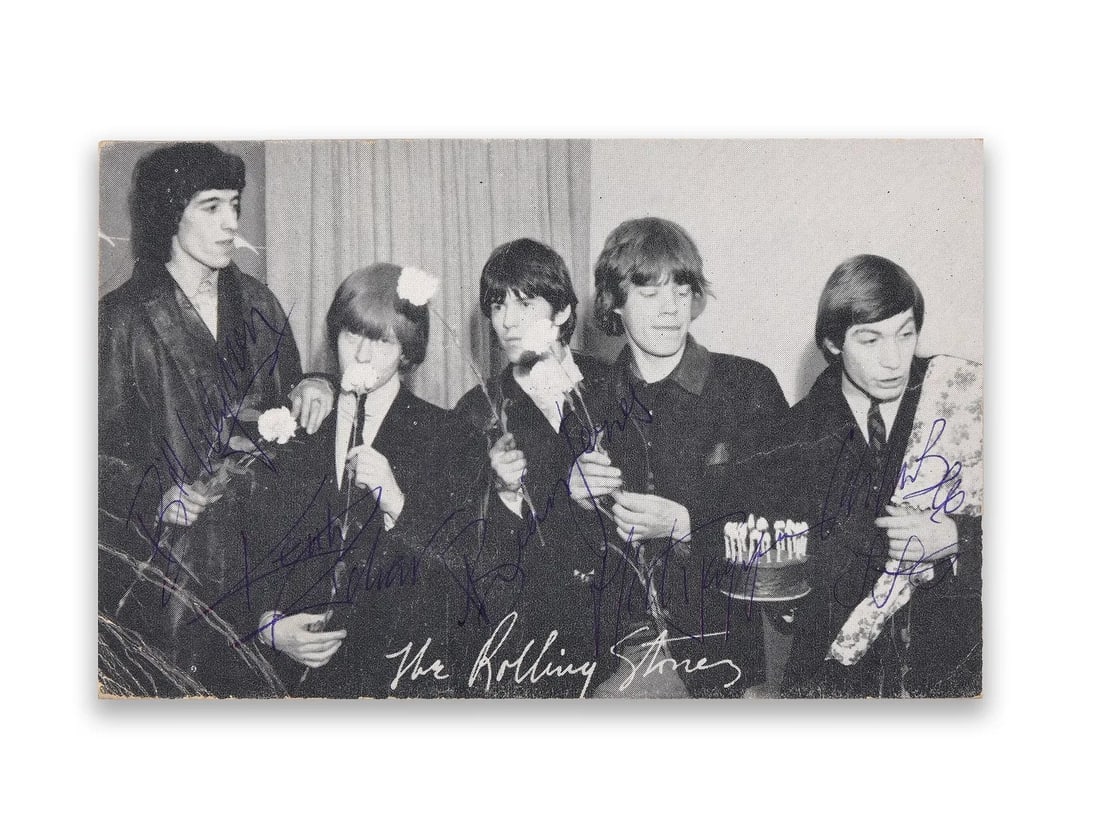 THE ROLLING STONES, MULTI-SIGNED PHOTOGRAPH POSTCARD BY THE ORIGINAL FIVE MEMBERS, CIRCA EARLY-MID: THE ROLLING STONES, MULTI-SIGNED PHOTOGRAPH POSTCARD BY THE ORIGINAL FIVE MEMBERS, CIRCA EARLY-MID 1960S Signature: Signed by the five original members of The Rolling Stones. Description: The image sh