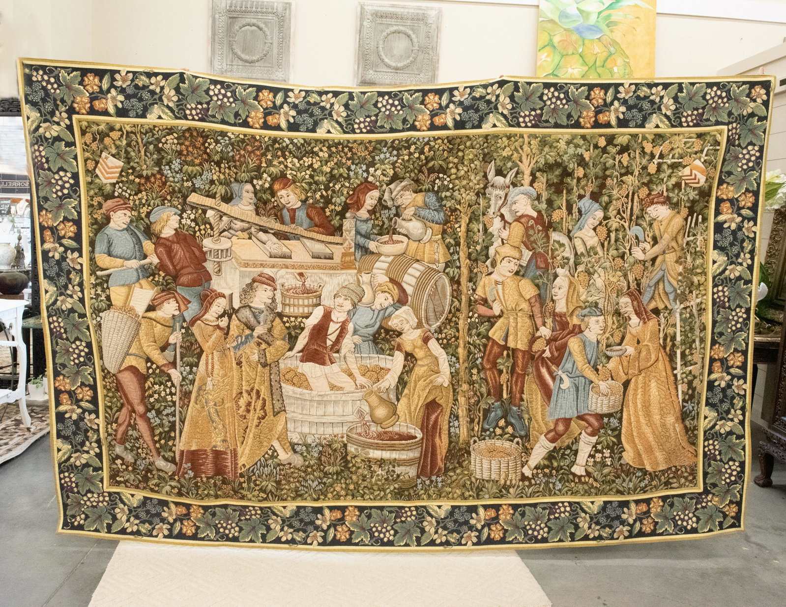 The Vintages Belgian Tapestry: This Belgian tapestry shows a representation of grape-gathering and the wine-press. The original, on a Mille-fleurs background, hangs in the Cluny museum in Paris.This reproduction is in excellent con