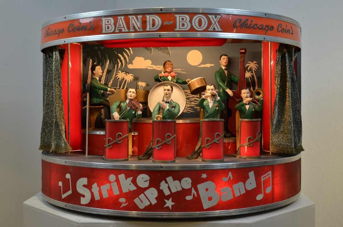 CHICAGO COIN'S BAND-BOX MODEL 50-100, "THE WORLD'S: CHICAGO COIN'S BAND-BOX MODEL 50-100, "THE WORLD'S SMALLEST BAND." A REMOTE, WALL-MOUNT ACCESSORY SPEAKER UNIT FOR A JUKE BOX. WHEN THE ATTACHED JUKE BOX IS PLAYED, THE BAND BOX LIGHTS GO ON, CURTAIN