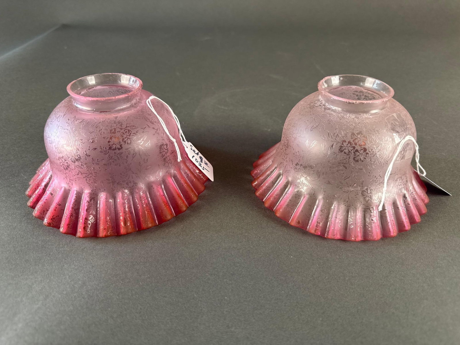 2 matching acid etched cranberry shades: 2 shades with intricate floral designs glass light fixtures Low Estimate: 20.00 High Estimate: 60.00